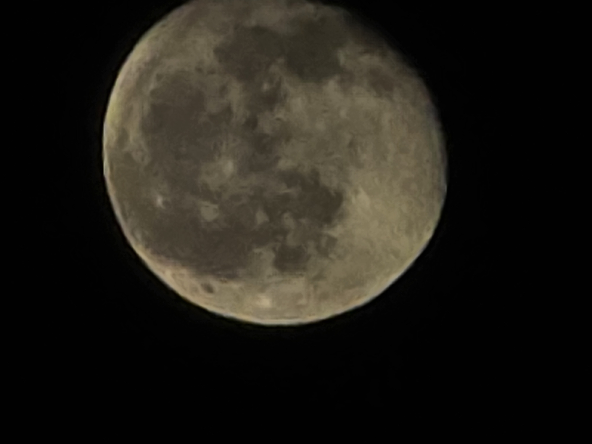 The image shows a close-up view of the moon against a black, starless sky. The moon is not fully illuminated, with a portion of its surface in shadow. The visible surface of the moon displays textured features, indicative of craters and maria. The lighting suggests it is night. There is no visible city or identifiable landmarks, therefore no information can be provided about its location in Yambol, Bulgaria.