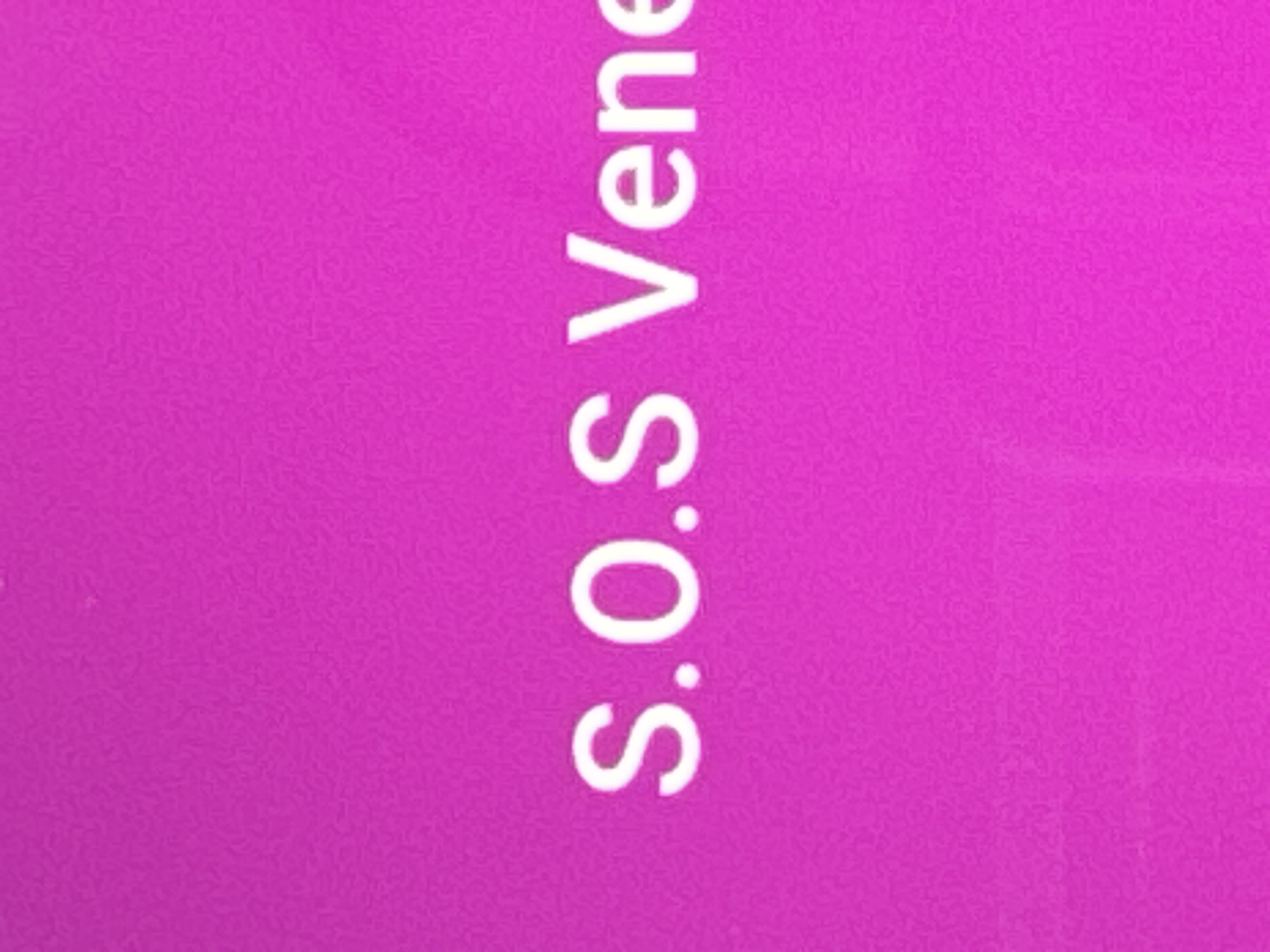 The image is a close-up of a bright pink surface with white text that reads "S.O.S Vene". The text is centered and appears to be printed or projected onto the surface. The surface has a slightly textured appearance, possibly due to the material it is made of or a lighting effect. There are no people or other objects visible in the image. The location in Kuta Selatan, Indonesia, is not discernible from the image itself.