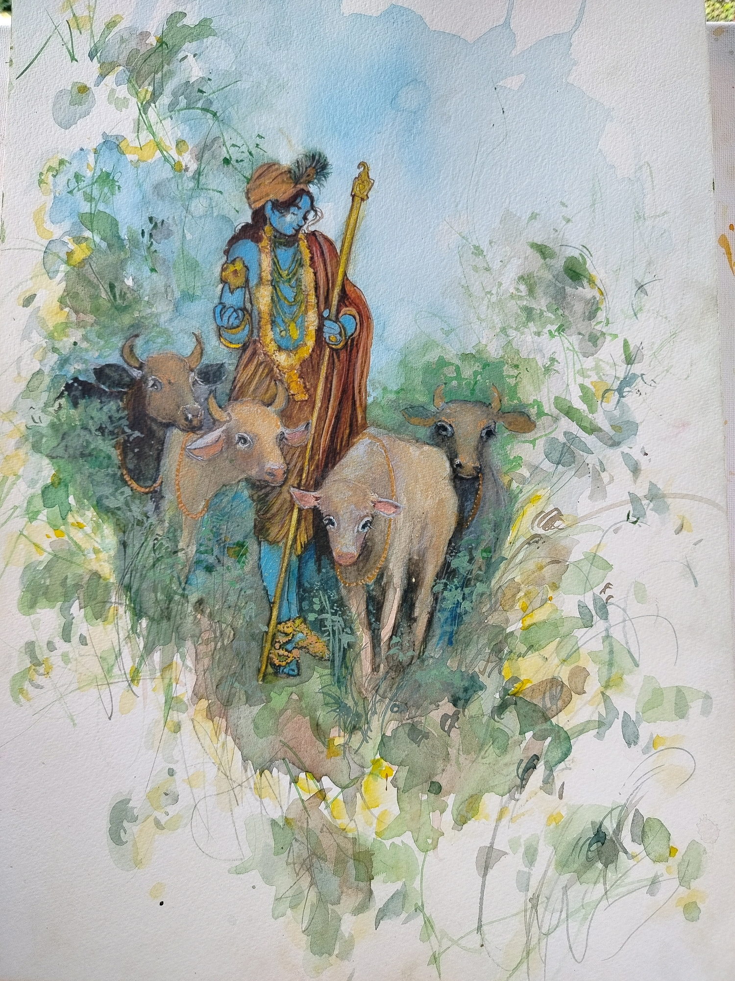 A watercolor painting depicts a blue-skinned figure, presumably Krishna, standing among several cattle. The figure wears a turban adorned with a feather and holds a golden staff. The cattle are of various colors, including brown and light tan, and wear decorative necklaces. The background features lush green foliage and a light blue sky. There is no discernible connection to the city of Gagra, Abkhazia.