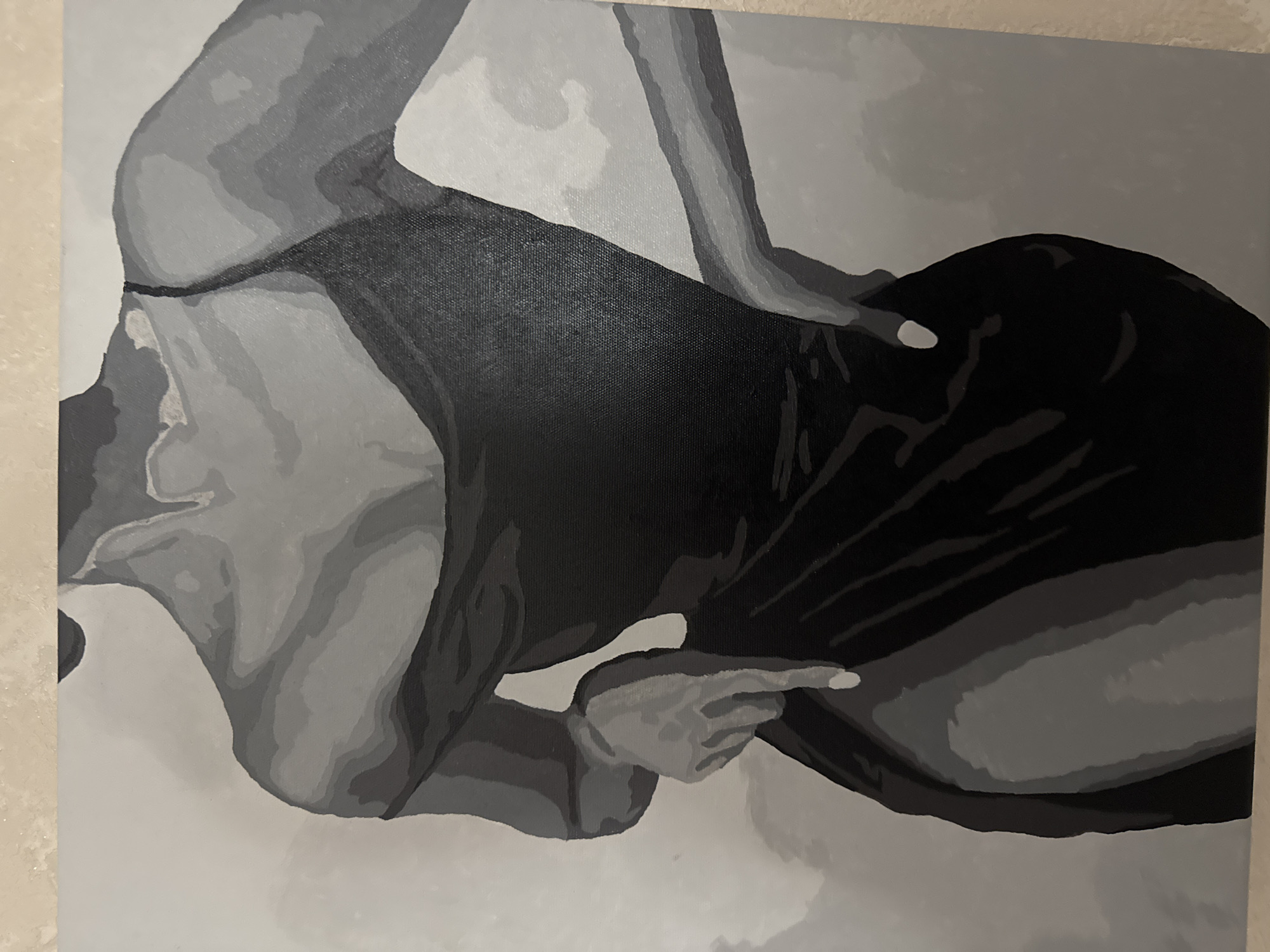 The image is a painting in grayscale. It depicts the upper body and thighs of a woman wearing a black dress with thin straps. The style is abstract and uses broad strokes of varying shades of gray to suggest form and shadow. The woman's hands are positioned on her hips. The background is a light gray. There is no indication of a specific location within Saratov, Russia.