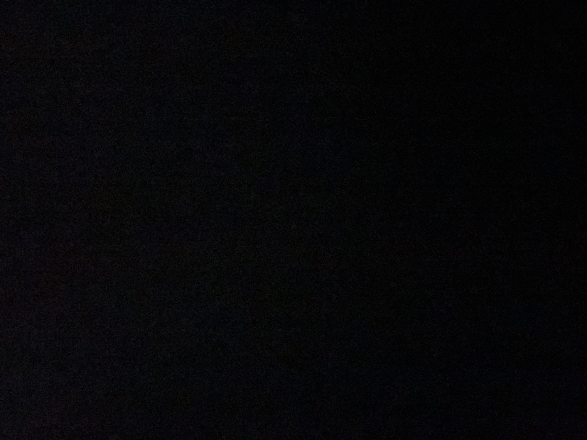The image is a close-up, dark, and grainy photograph of a black surface. There are no discernable objects, people, or environmental details visible in the image. The texture suggests a fabric or textured paper, but without any context or illumination, it is impossible to determine the exact material or its setting. The image offers no information about Casablanca, Morocco, or any specific location within it.