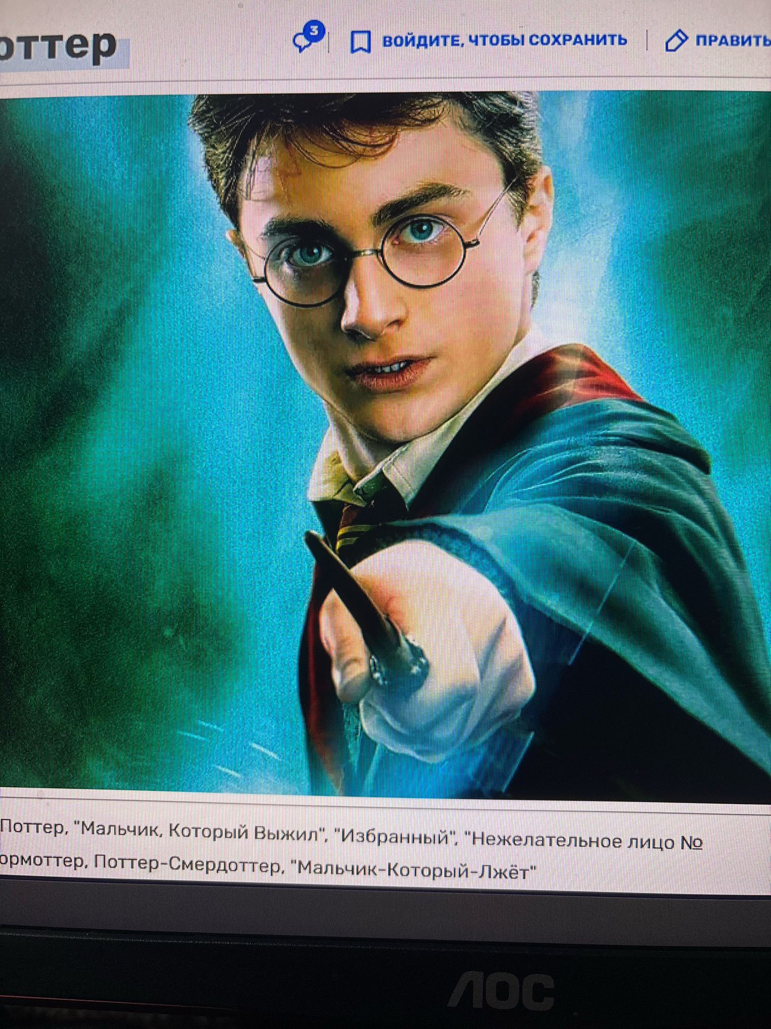 The image shows a computer screen displaying a promotional image of Harry Potter. The screen is viewed from a slightly elevated angle, indicating it is likely in a home or office environment. Text overlays on the screen include "ойдите, чтобы сохранить" and "ПРАВИТЬ", suggesting a website interface in Russian. Below the image of Harry Potter, there is text in Russian that appears to be a list of titles or descriptions related to the character. The lower part of the screen shows the logo "ЛОС", which is likely a brand of computer monitor. There is no information in the image that provides any details about the location within the city of Novocheboksarsk, Russia.
