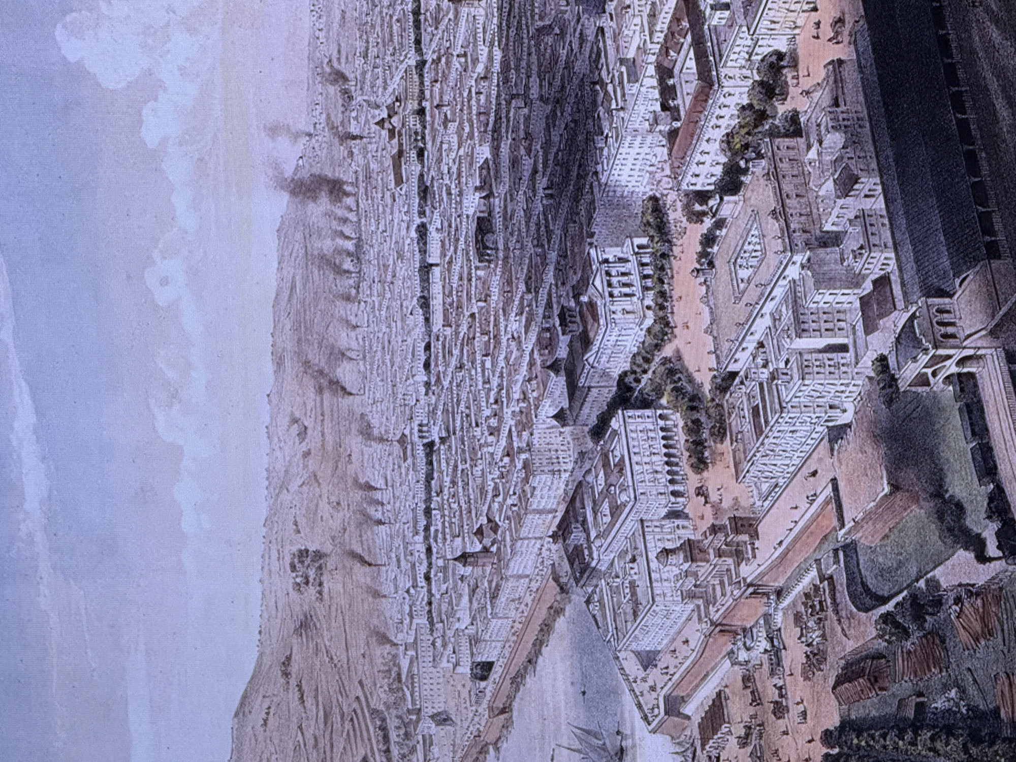 This is a wide, aerial view of a densely populated city with intricate architecture, likely an old European city, not Dubai. The image is rendered in a historical illustration style, possibly an engraving or painting. Buildings are densely packed, featuring multiple stories, pitched roofs, and courtyards. The perspective emphasizes the vastness of the urban landscape, with a hazy, light-colored sky suggesting either a distant horizon or a stylized depiction.
In the foreground and midground, there are visible signs of urban life. Streets are lined with buildings, and some figures are depicted, appearing small in scale due to the aerial viewpoint, suggesting human activity within the city. There are also trees and green spaces interspersed throughout the urban fabric. A prominent, dark, rectangular structure dominates a portion of the right side of the image, possibly a large public building or a fortification. The overall impression is of a bustling, historic city. The image does not contain any visible text. The orientation of the image suggests it might have been scanned or photographed at an angle, as the main city elements are oriented vertically.