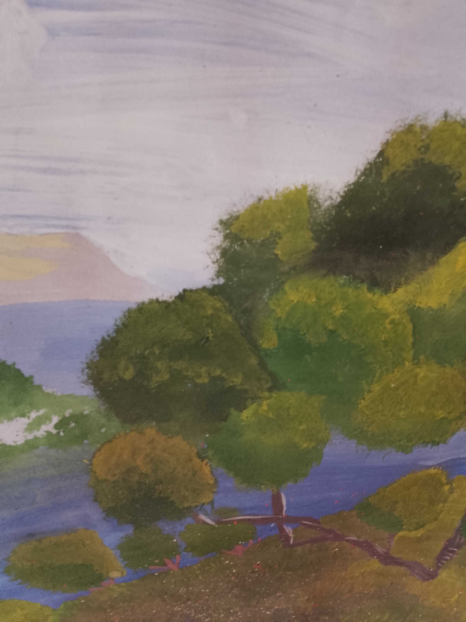 This is a close-up, vertical, eye-level shot of a painting. The painting depicts a landscape scene with a body of water, trees, and a distant mountain under a cloudy sky. The style appears to be watercolor or gouache, with visible brushstrokes and a somewhat impressionistic quality. The foreground is a grassy area with scattered red flecks, possibly representing flowers. Two trees with brown trunks and green foliage are prominent. A large body of water, colored in shades of blue, occupies the middle ground. In the background, a light-colored mountain range is visible against a sky filled with pale blue and white clouds. The painting does not contain any discernible elements that would indicate its specific location in Dniprovske, Ukraine.