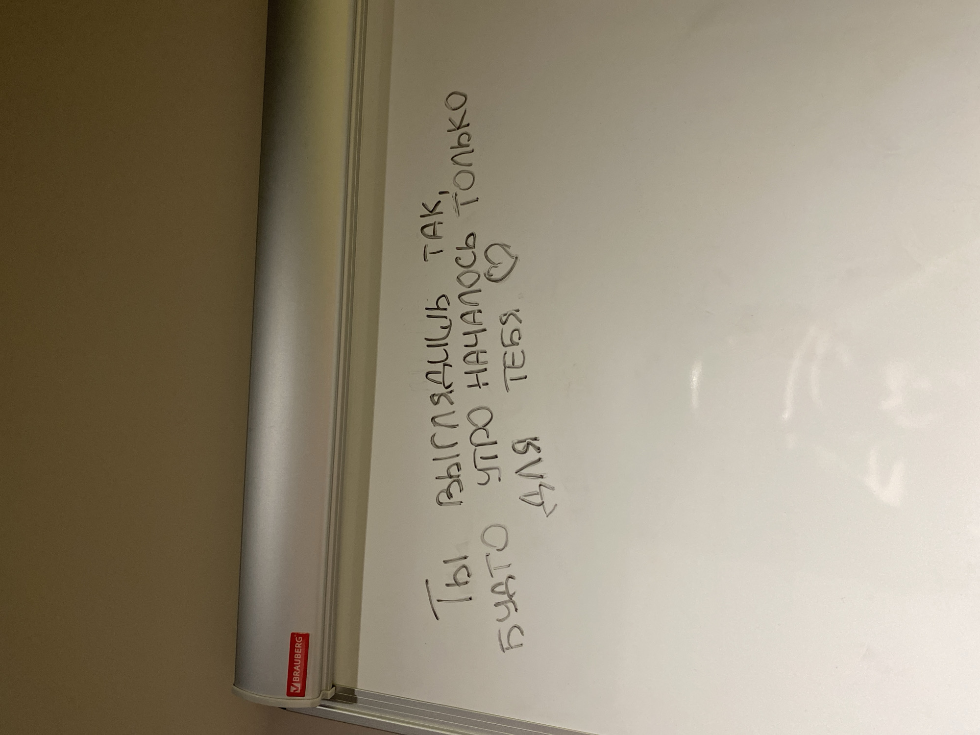 The image shows a whiteboard with text written on it in Russian. The text translates to: "You look so, so the morning has only started for you." There is a heart drawn at the end of the text. The whiteboard has a "Brauberg" logo on the lower left corner. The context and location in Votkinsk, Russia, cannot be derived from the image.
