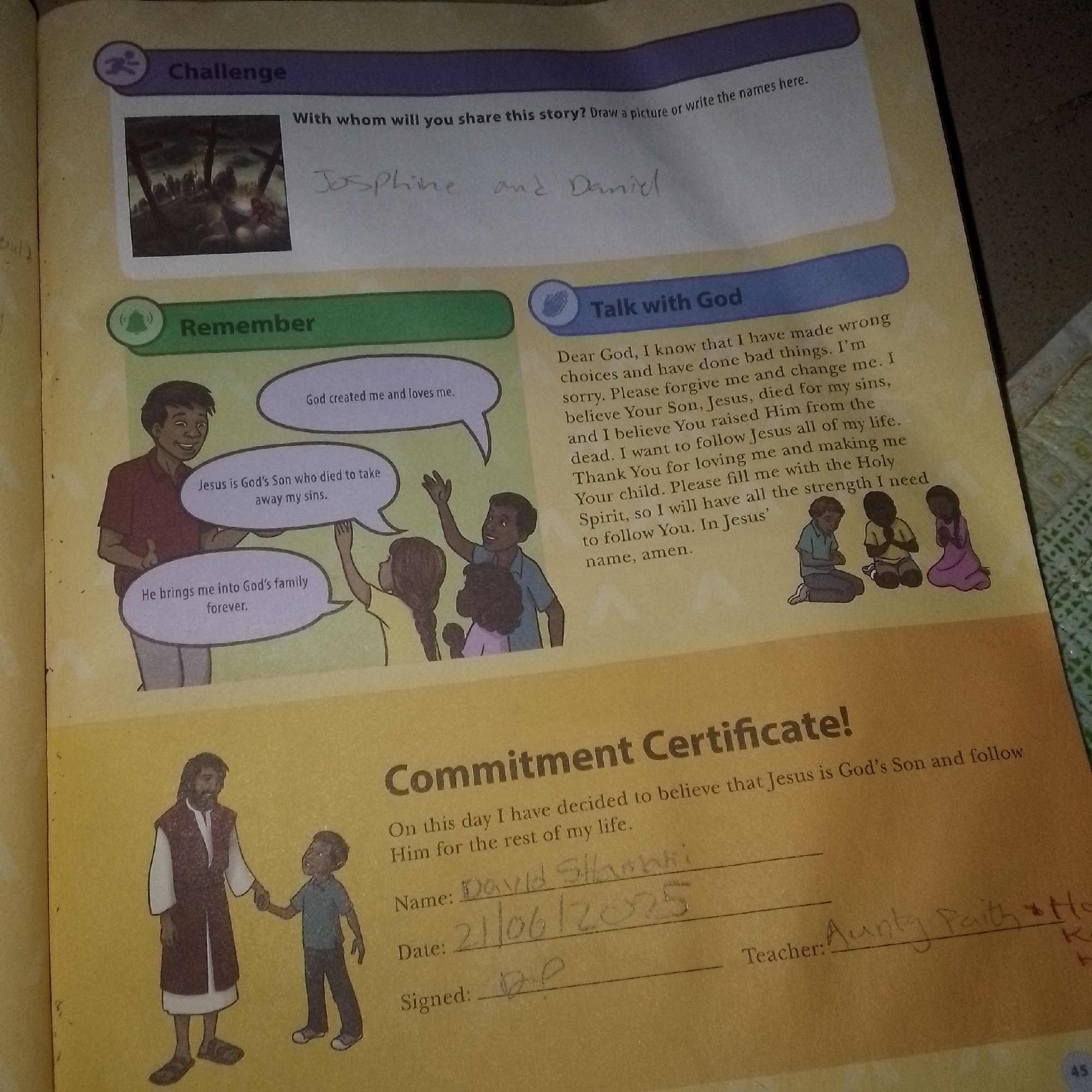 The image is a close-up, high-angle shot of a page from a workbook or educational material, likely religious in nature, as suggested by the content. The page is yellow with some yellowing and wear.
At the top left, there's a section titled "Challenge" with an icon of a running figure. Below this is a small, dark-toned illustration of several crosses, some with figures on them, implying a scene of crucifixion. To the right of this illustration, handwritten text in cursive reads: "Josephine and Daniel".
Below the "Challenge" section, a green bar contains the word "Remember" with a bell icon. To the right of this, a blue bar is titled "Talk with God". This section contains a prayer written in typed font, addressing "Dear God" and asking for forgiveness and strength to follow Jesus. Below the prayer are small illustrations of three children, two boys and a girl, kneeling with their hands together in prayer.
Further down, a large illustration shows a man with a beard, wearing a robe and vest, holding the hand of a young boy. Speech bubbles emanate from this illustration. One bubble above the man says, "Jesus is God's Son who died to take away my sins." Another bubble above the boy says, "He brings me into God's family forever." Another bubble, partially visible at the top, states, "God created me and loves me."
The bottom section of the page is dominated by the heading "Commitment Certificate!". Below this, in a larger font, is the text "On this day I have decided to believe that Jesus is God's Son and follow Him for the rest of my life." Underneath this are lines for writing: "Name:", "Date:", and "Signed:". Handwritten entries are visible: "David Sthmani" for the name, "21/06/2075" for the date, and "D.P" for the signature. To the right of these lines, another handwritten entry reads "Teacher: Aunty Faith *Ho K K". There is a page number "45" in the bottom right corner.
The image depicts educational content, likely for children, with a focus on Christian teachings. The handwritten entries indicate personal responses and participation. The environment appears to be an indoor setting, possibly a classroom or home, given the context of a workbook. There is no indication of a specific city or location beyond what is implied by the workbook content itself.