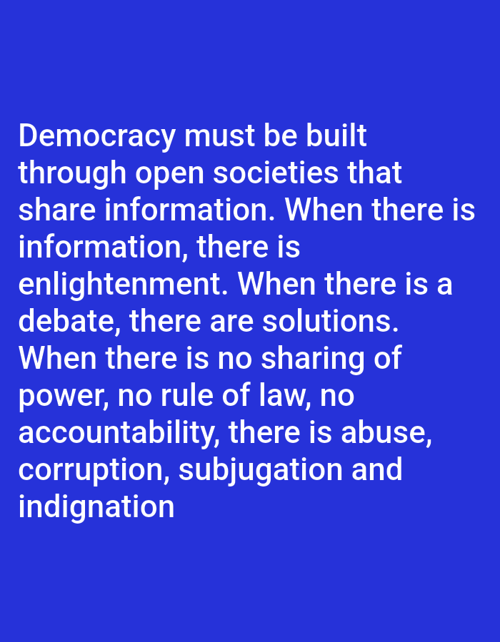The image is a photograph of a blue background with white text. The text reads: "Democracy must be built through open societies that share information. When there is information, there is enlightenment. When there is a debate, there are solutions. When there is no sharing of power, no rule of law, no accountability, there is abuse, corruption, subjugation and indignation." There are no people, subjects, objects, actions, interactions, or environmental details visible in the image, other than the text itself. The location of Payagaboh, Indonesia is not relevant to the image content.