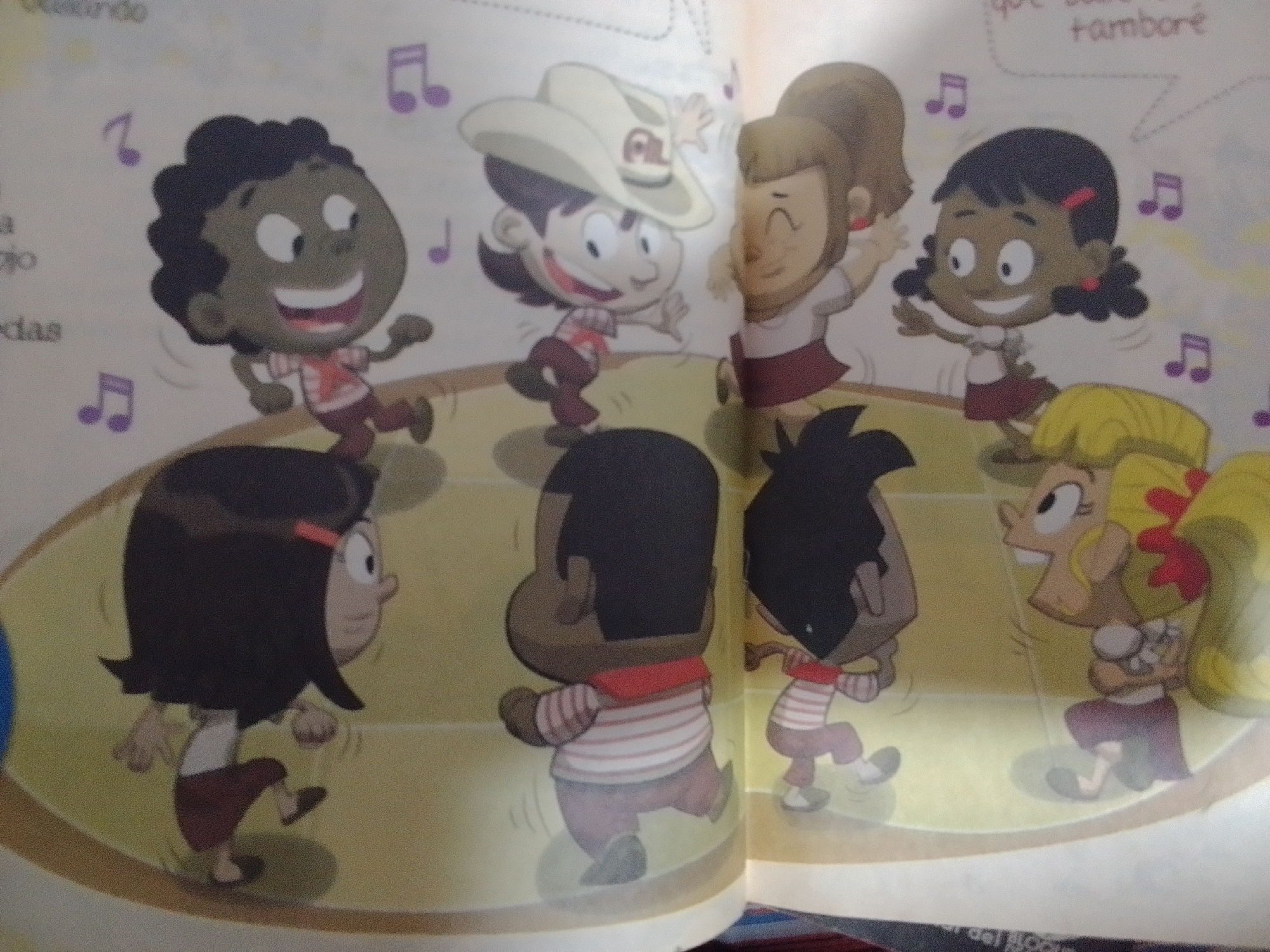 The image depicts a colorful illustration of several cartoon children dancing. In the foreground, a Black child with dark curly hair is shown from the side, wearing a red and white striped shirt and maroon pants, with their right leg raised as if mid-dance. To the left, a Black child with dark, short hair, wearing a red and white striped shirt and maroon pants, is facing forward and smiling widely with their arms outstretched. In the middle left, a child wearing a large white cowboy hat with a red emblem, a red and white checkered shirt, and maroon pants is captured in a dynamic dance pose. To the right of the cowboy-hatted child, a girl with blonde hair tied in a ponytail, wearing a white top and a maroon skirt, is also dancing. Further to the right, a child with dark hair and pigtails, adorned with red hair ties and earrings, wearing a white top and a maroon skirt, is depicted dancing. Behind these figures, a child with dark, spiky hair, wearing a red and white striped shirt and maroon pants, is dancing. In the lower right, a child with blonde hair styled in large curls, wearing a white top and maroon pants, is shown with their head tilted back, smiling and holding something small in their hands. The children are positioned on a light yellow, circular platform, which appears to be a stage. Purple musical notes are scattered throughout the background, suggesting a musical or celebratory context. Text in Spanish is partially visible in the upper section of the image. There is no discernible information within the image that places the scene in La Tagua, Venezuela.