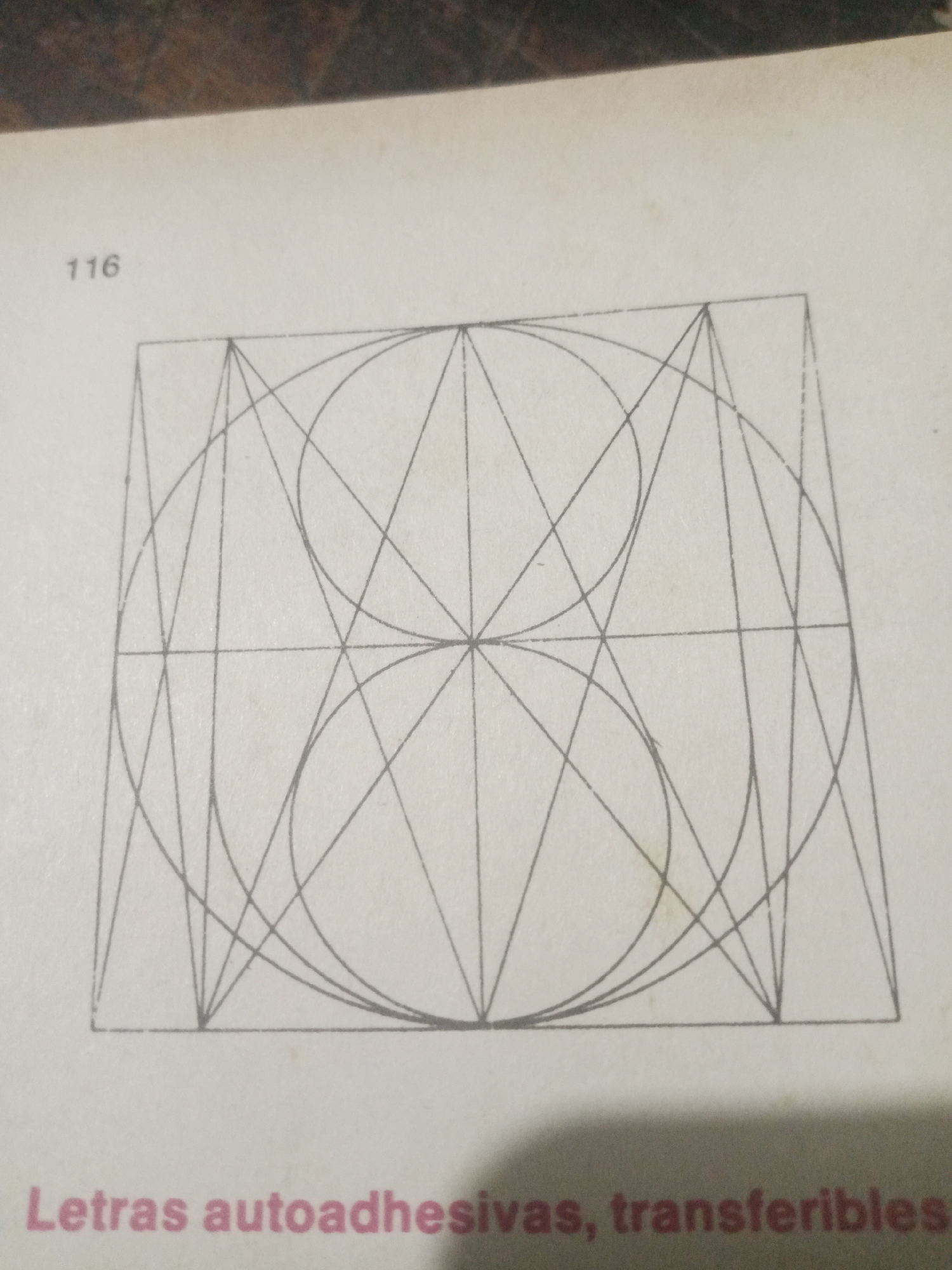 The image displays a page from a book or catalog, featuring a geometric drawing and text. At the top left, the number "116" is visible. The central part of the image is dominated by a complex geometric construction within a square frame. This construction consists of intersecting lines and arcs, forming a symmetrical pattern with curved and straight elements. Below the drawing, the text "Letras autoadhesivas, transferibles" is printed in a pinkish-red color. The overall impression is that of an instructional or catalog page related to graphic design or lettering. There is no indication of a specific location in Santa Ana, Venezuela, or any people or actions depicted.