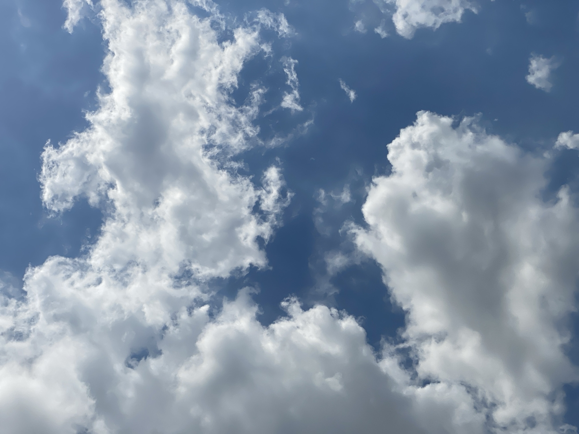 The image shows a cloudy blue sky with cumulus clouds. There is no indication of the city of Berangas Timur, Indonesia in the image. The scene is entirely natural and lacks any human elements or man-made objects.