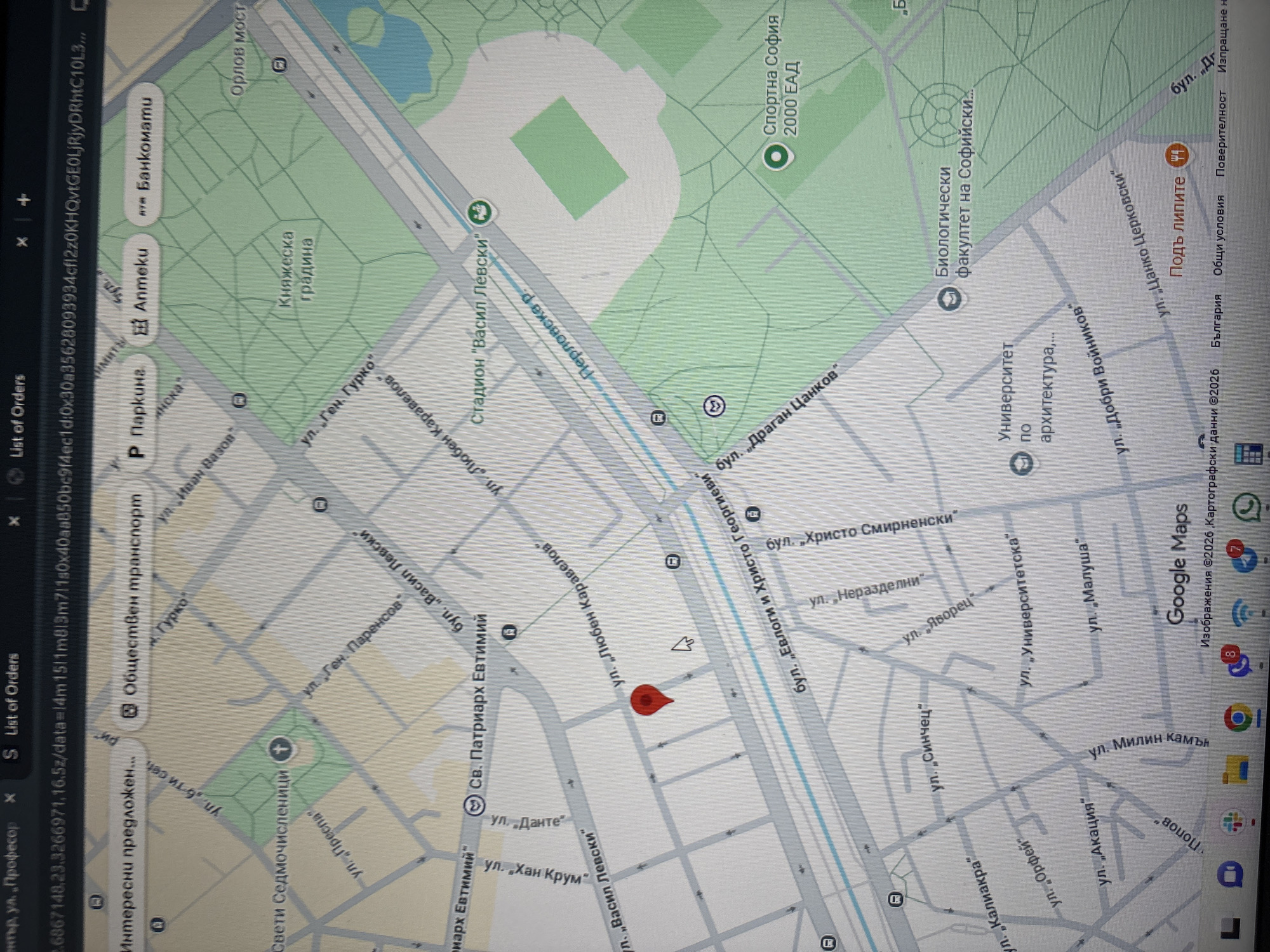 The image is a screenshot of a Google Maps view of a location in Sofia, Bulgaria. The map displays streets, parks, and landmarks. The red pin indicates a specific location near the intersection of "ул. Любен Каравелов" and "бул. Евлоги и Христо Георгиеви". Nearby landmarks include the "Св. Патриарх Евтимий" boulevard and the "Васил Левски" stadium. Other visible locations include "Княжеска градина" and the "Биологически факултет на Софийски". A list of orders sidebar is also visible on the left side of the screen.