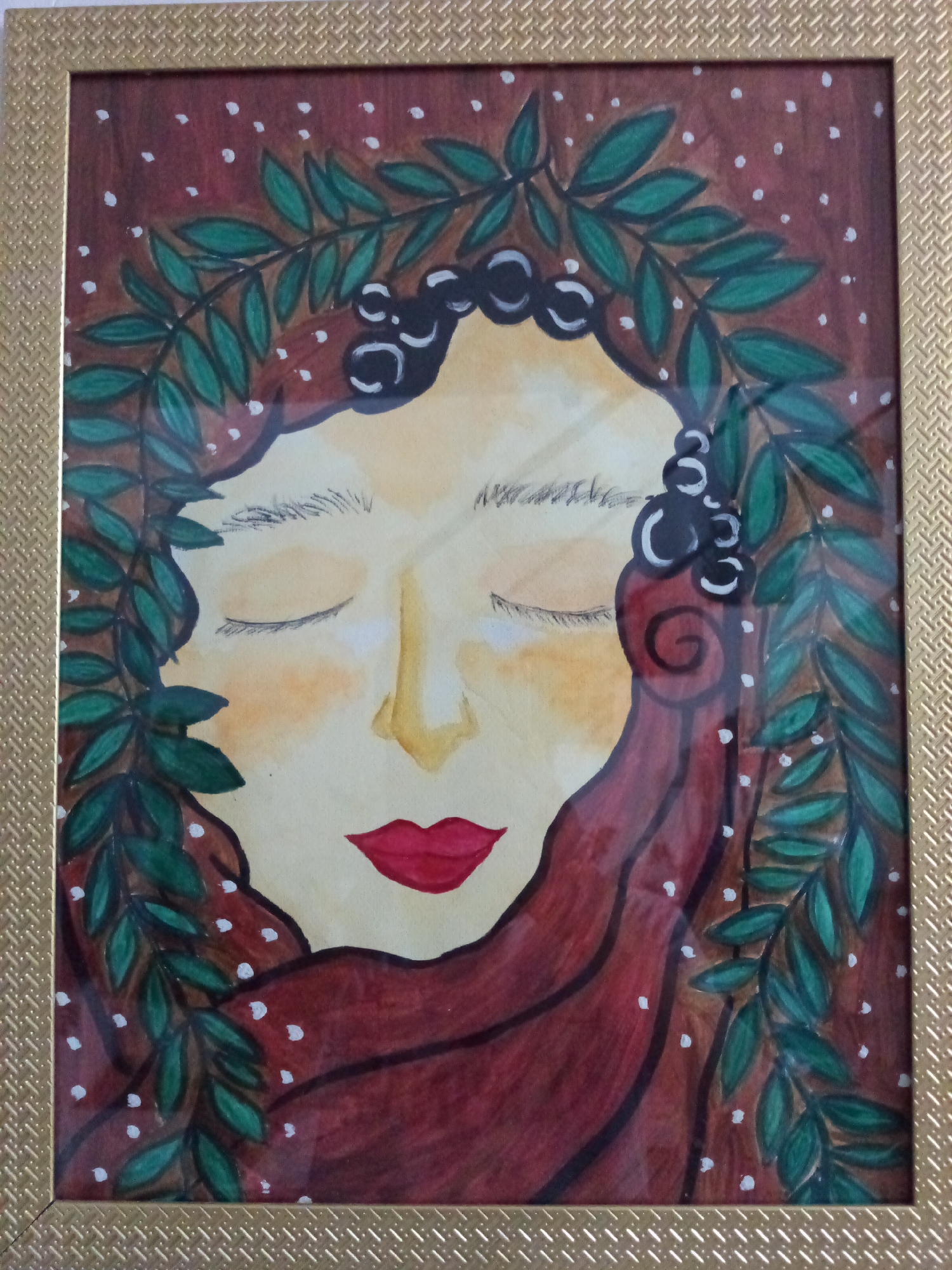 A framed watercolor painting depicts a woman with closed eyes. She has fair skin, a yellow-tinted nose, and red lips. Her dark hair is adorned with a wreath of green leaves and black berries. A reddish-brown cloth drapes around her head and neck. The background is a mottled brown with small white dots. The painting is framed in a gold-colored frame with a textured pattern. The location is unknown, though it has been specified that the location may be in the city of Davao City, Philippines.