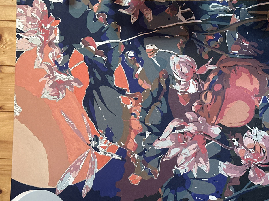 A partially completed paint-by-numbers canvas depicting a natural pond scene is presented, observed in 3-Y Uchastok, Russia. The canvas rests against a light-colored wooden surface, visible at the top edge of the image. The artwork features a prominent reddish-brown frog in the lower-right quadrant, its body mostly painted, facing right. Multiple pink and white water lilies, some fully painted and others displaying numbered sections (e.g., 15, 20), surround the frog and are scattered across the lower and central portions of the canvas. In the upper-left quadrant, a light blue and grey dragonfly with segmented wings is depicted in flight, with several numbered areas (e.g., 16, 17, 36) still unpainted on its body and wings. The background includes a large, circular, coral-orange shape, suggestive of a celestial body like a sun or moon, with a partial white circle visible in the extreme upper-left corner. The overall environment is characterized by dark blue, dark green, and purple tones representing water and foliage. The canvas displays visible black outlines and numerical indicators for unpainted regions across the entire scene.