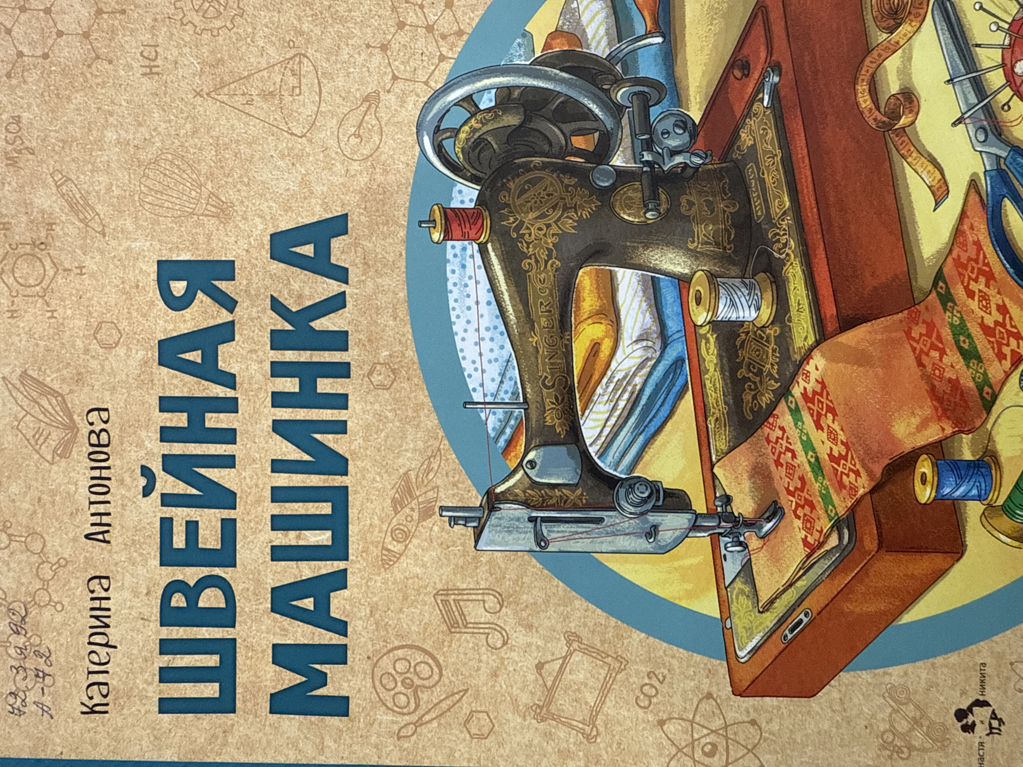The image is a close-up of a book cover. The title "ШВЕЙНАЯ МАШИНКА" (Sewing Machine) is prominently displayed in blue, alongside the author's name "Катерина Антонова" (Katerina Antonova). An illustration features an antique Singer sewing machine with colorful spools of thread and fabric. The background is decorated with sketches of scientific diagrams, musical notes, and art supplies. The names "настя" and "Никита" are visible in small print at the bottom right corner. The image is located in the city of Votkinsk, Russia.