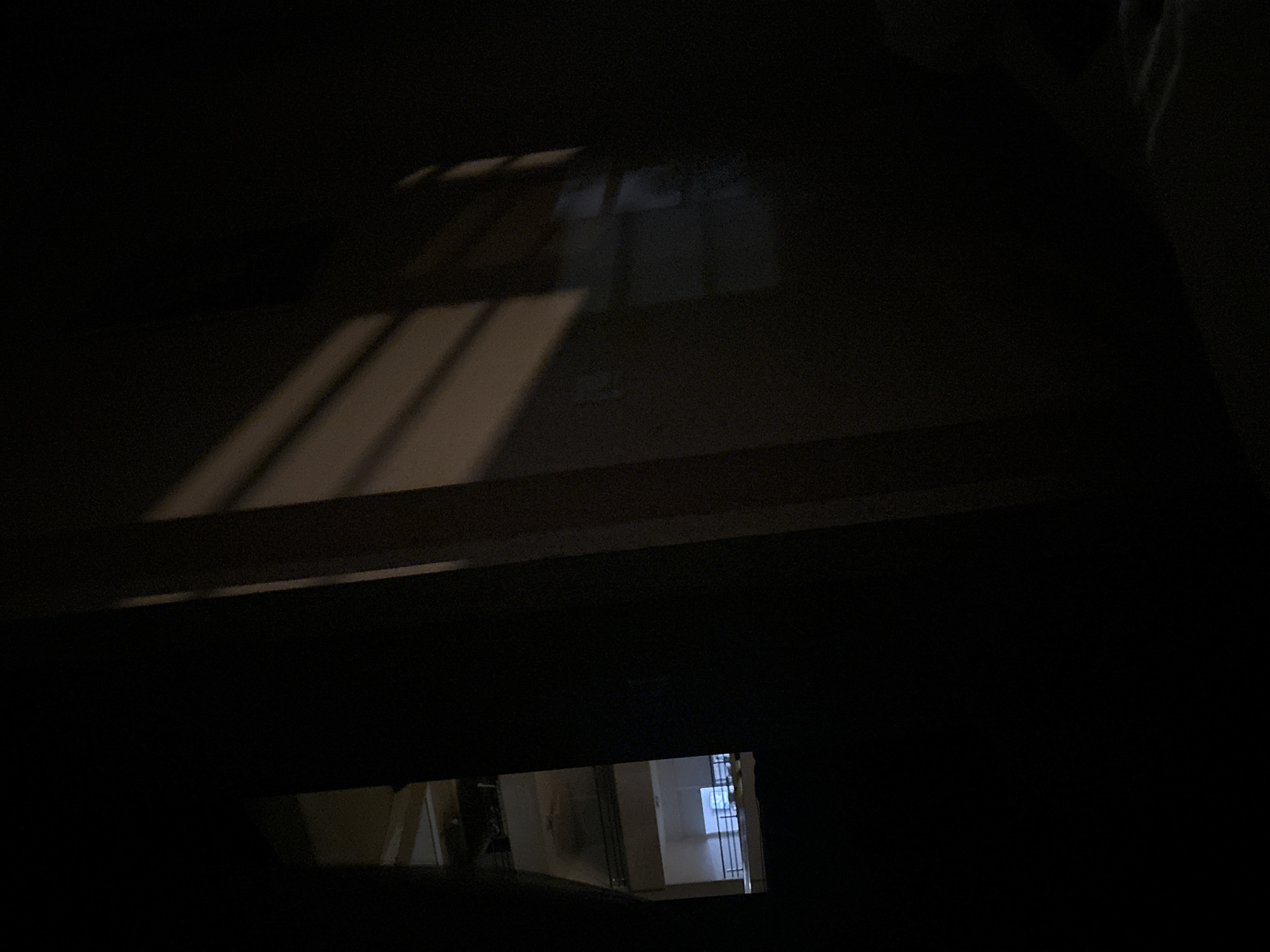 The image shows a dark interior with light coming in through barred windows. The location cannot be determined based on the image alone.