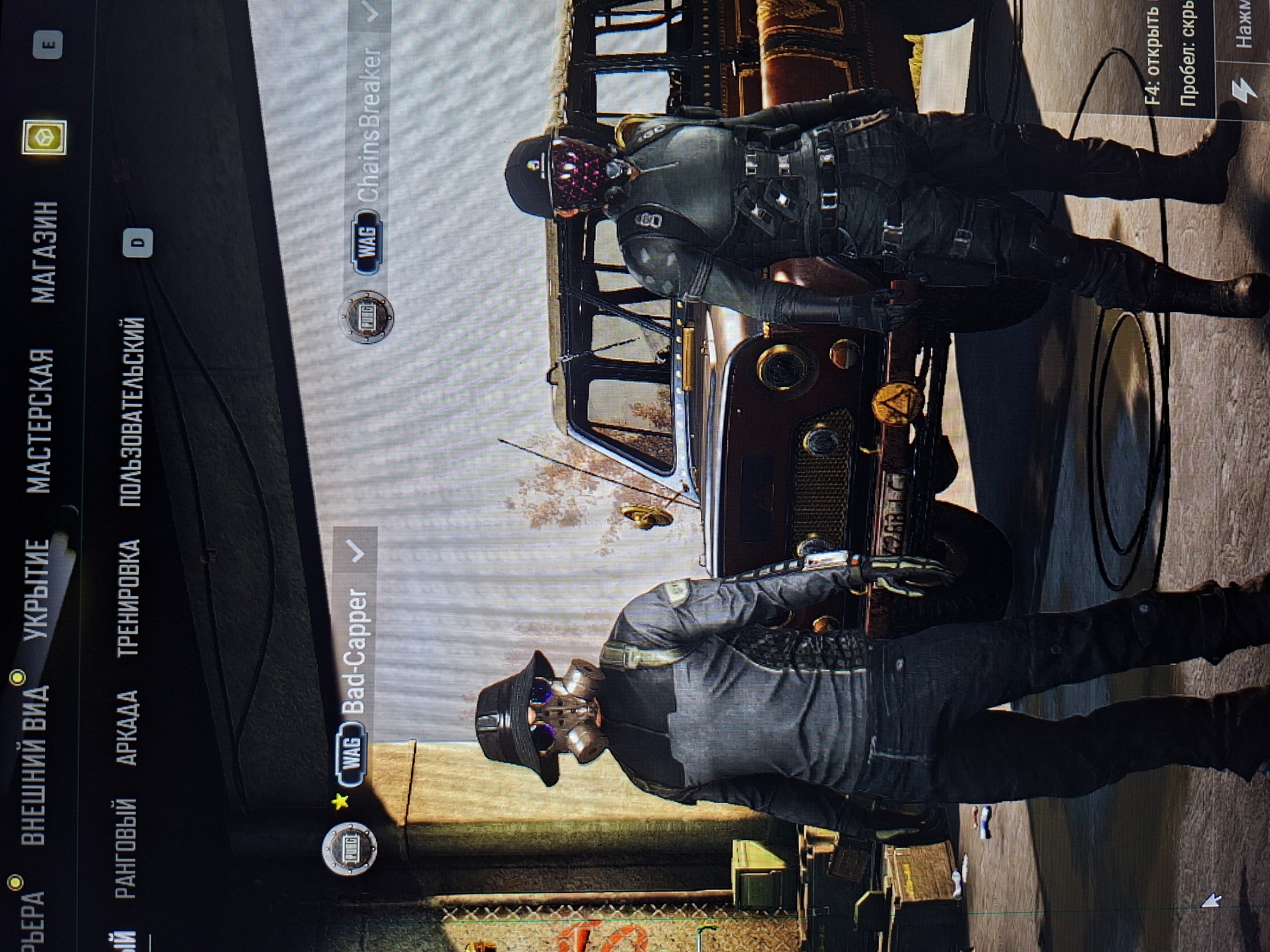 Two characters from the game PUBG Mobile are displayed in front of a brown vehicle. The character on the bottom is named "Bad-Capper" and the character on the top is named "Chains Breaker". On the left of the screen are Russian menu options, including " внешни вид" (appearance). At the top right corner, Russian text reads "F4: Open" and "Space: Hide". The exact location within the game is not explicitly stated.