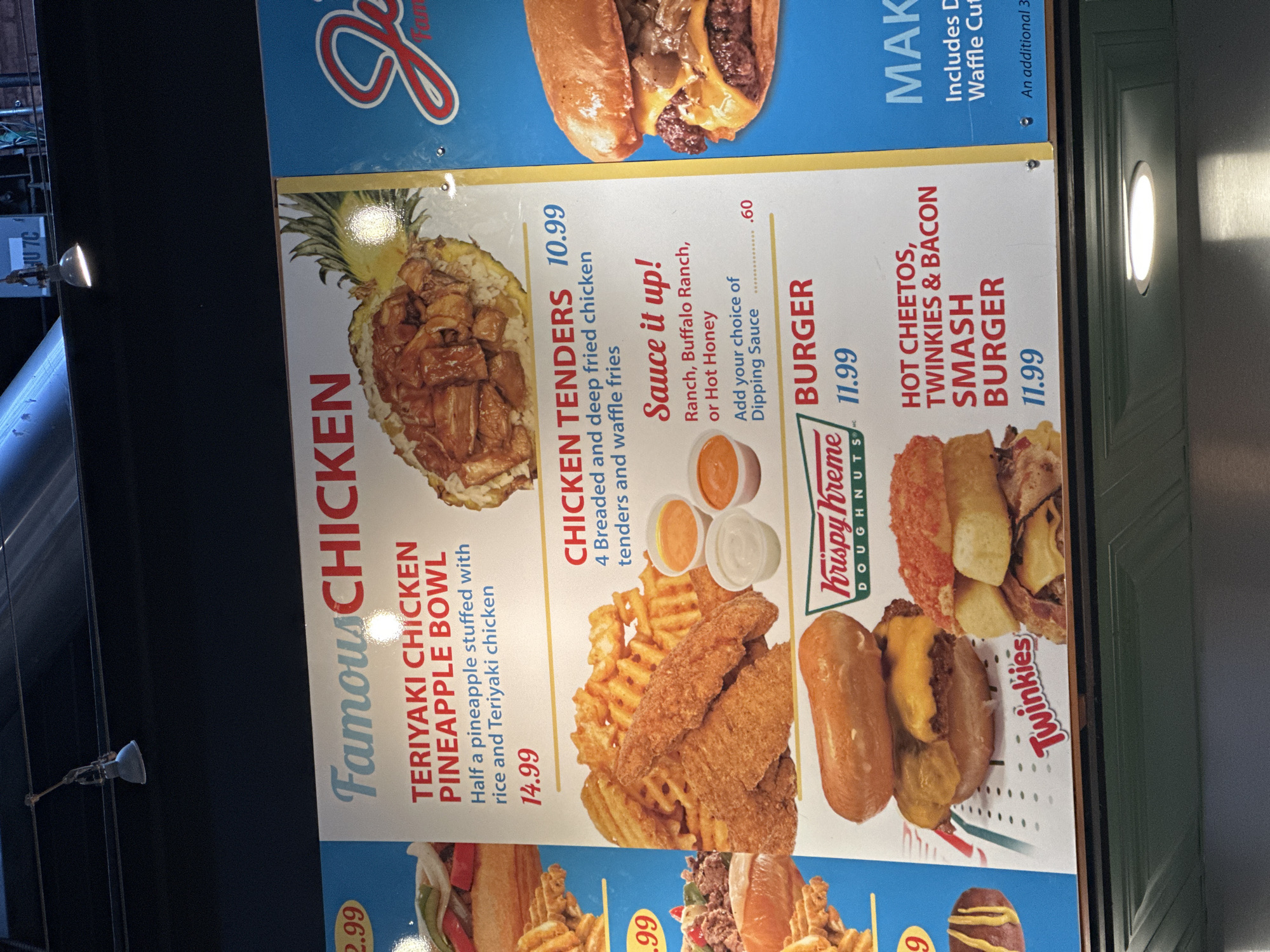 A sign advertising food from a restaurant is partially visible. The sign advertises chicken items, a burger, and a "smash burger." The advertised restaurant is likely in Tampa, Florida, given the presence of the "HU7C" sign, which identifies a Tampa food truck.