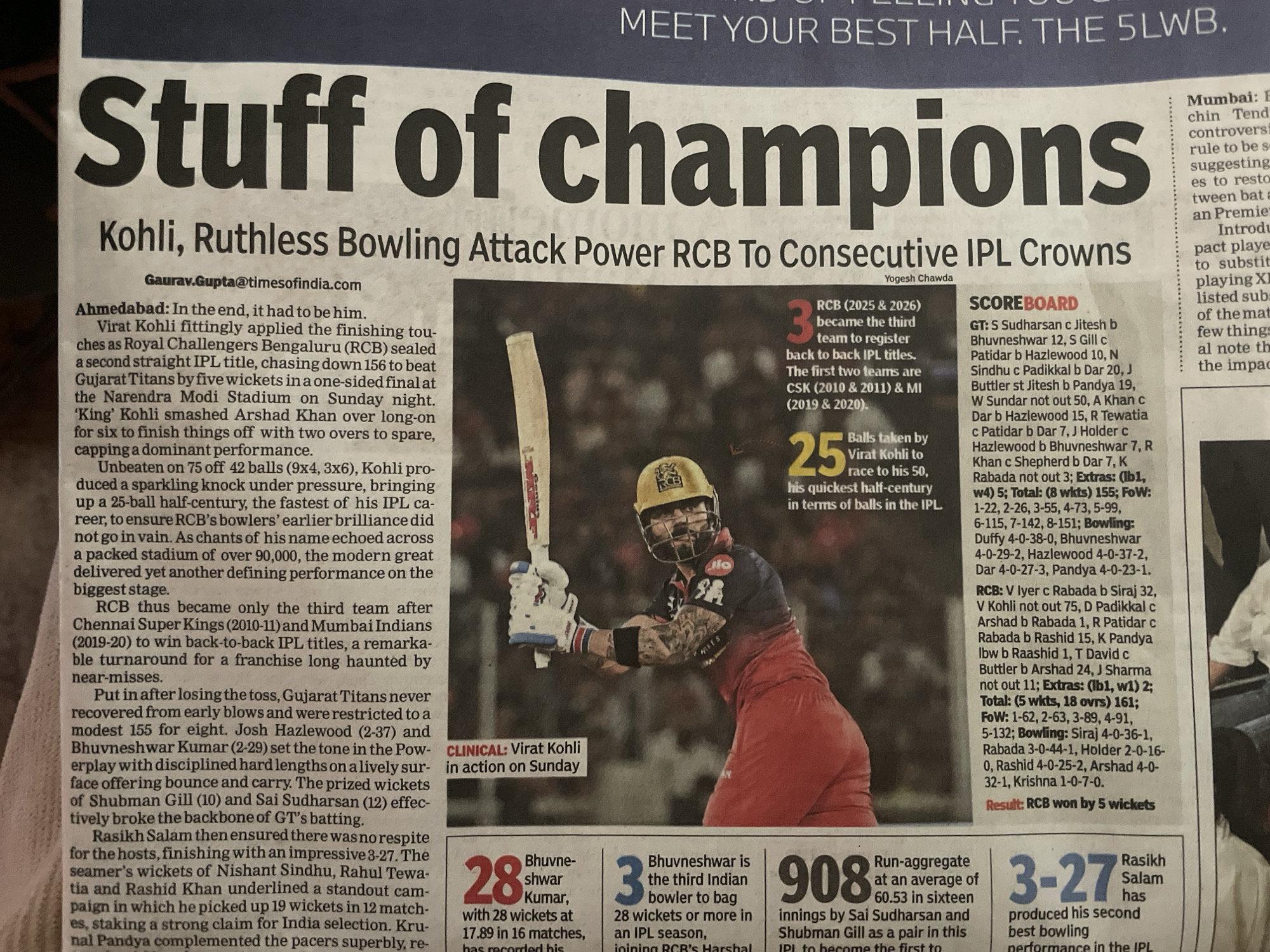This is a photograph of a newspaper article titled "Stuff of Champions: Kohli, Ruthless Bowling Attack Power RCB to Consecutive IPL Crowns". The article features a picture of cricketer Virat Kohli batting, with a scoreboard and statistical highlights from an IPL (Indian Premier League) match. The article discusses Kohli's performance and RCB's (Royal Challengers Bengaluru) victory. Numerical data and records relating to the match are presented. The photograph was likely taken indoors under artificial light. There is no indication that the photograph was taken in Chandigarh, India.
