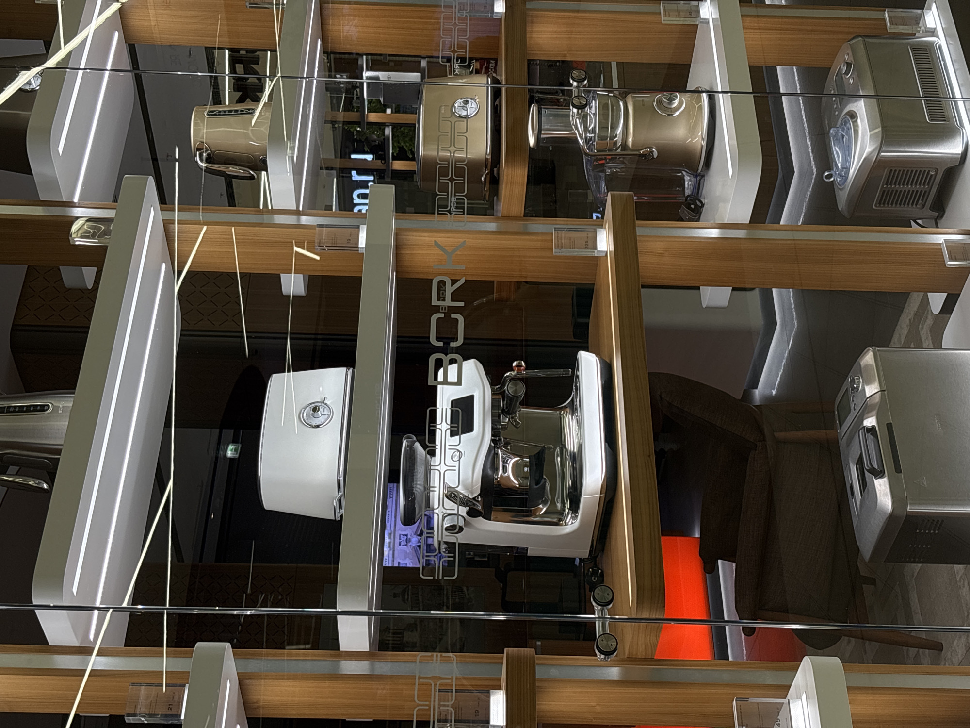 The image shows a display case of BORK brand small kitchen appliances, including coffee machines and food processors. The display is likely in a BORK retail store. The city mentioned, Perm, Russia, cannot be verified as the location from the visual information.