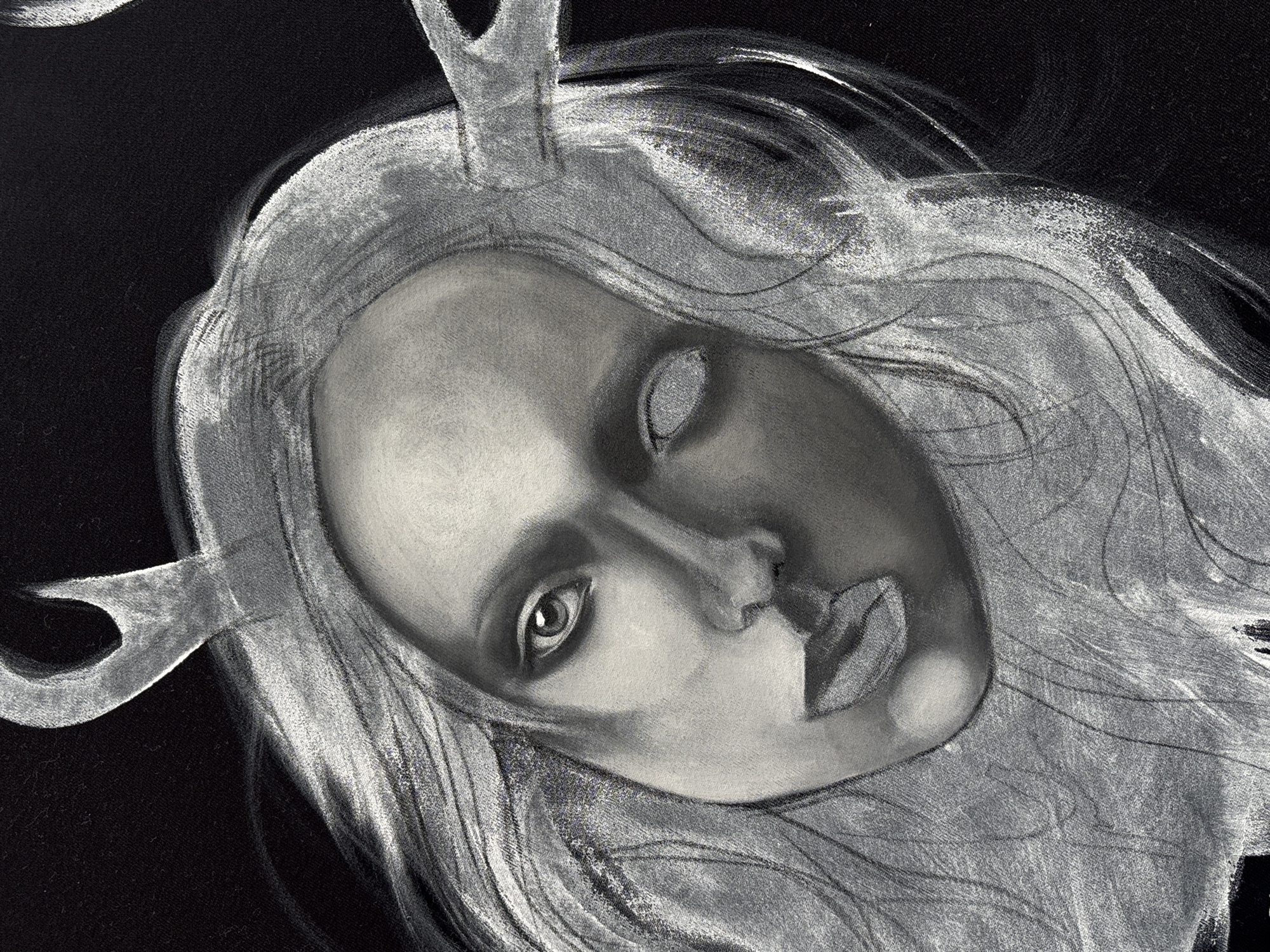 A black-and-white drawing or illustration depicts a person's face with stylized antlers or horns emerging from the forehead or head area. The individual has one eye visible, while the other is obscured or missing detail. The visible eye is detailed, with a defined pupil and iris. The face is shaded to create depth, with light highlighting the nose, lips, and forehead. The person has a soft, somewhat androgynous appearance. The hair is depicted with loose strokes and seems to cascade around the face. The background is predominantly black, providing contrast to the lighter tones of the figure. There are no indications of the location being Krasnoyarsk, Russia.