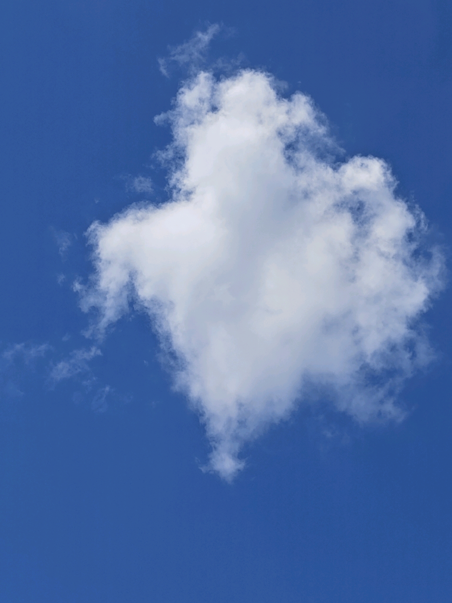 A single, large, white cumulus cloud is centered in a deep blue sky. The cloud has a rounded, puffy top and tapers to a point at the bottom. Wispy tendrils of smaller clouds extend from the left side of the main cloud. There is no visible indication of the city of Mu Si, Thailand, or any other geographical markers.
