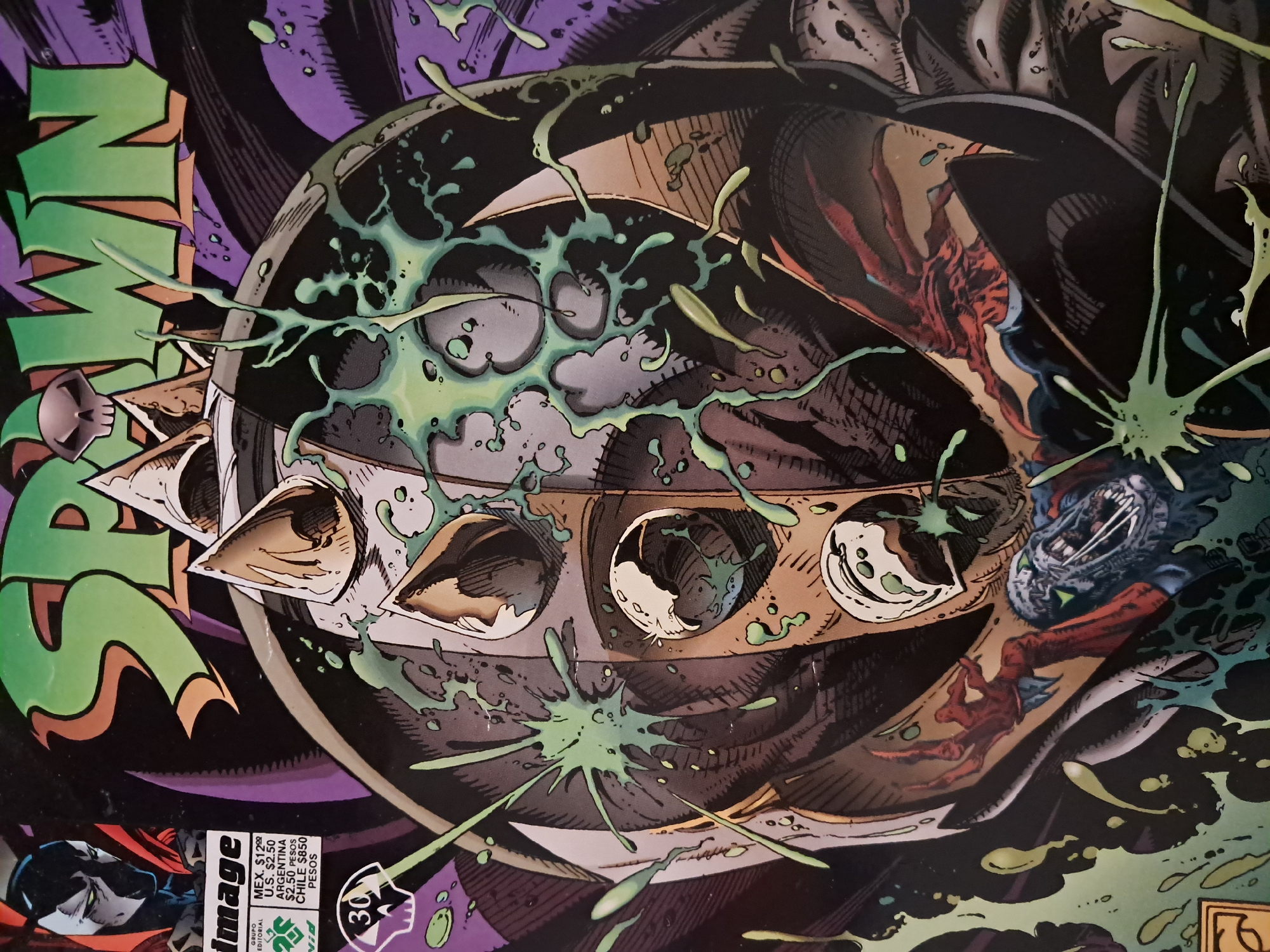 The image shows a close-up of a Spawn comic book cover. Dominating the frame is a round, metallic object with spike-like protrusions, possibly part of Spawn's costume or weaponry. Green, viscous liquid splatters across the object. Parts of Spawn's character are visible, including his face and red costume details. The comic's title, "SPAWN", is partially visible in green lettering. The Image Comics logo and pricing information, including "$2.50 PESOS ARGENTINA," are in the lower-left corner. Vicente López, Argentina, is NOT visible.