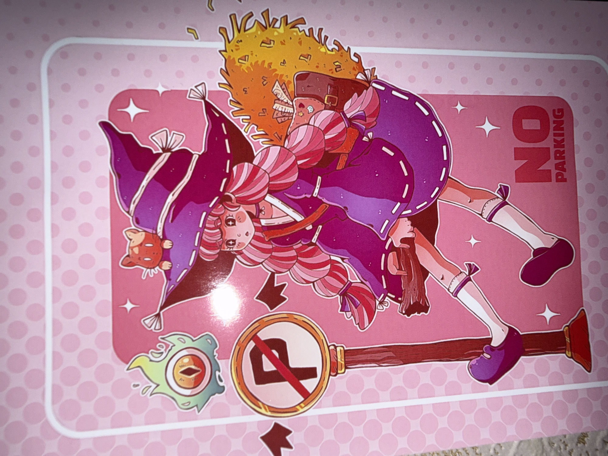 The image is a digital illustration of a young witch with pink and red striped hair, wearing a purple dress and hat. She is standing next to a "No Parking" sign with a red circle and slash over a "P". To her left is a cartoonish green monster with an eye, and to her right is a broomstick with a haystack attached. A small orange cat is sitting on her hat. The background is a light pink with white polka dots. The text "NO PARKING" is visible at the bottom right of the image. The location of Pudomyagi, Russia is not depicted or implied in this image.