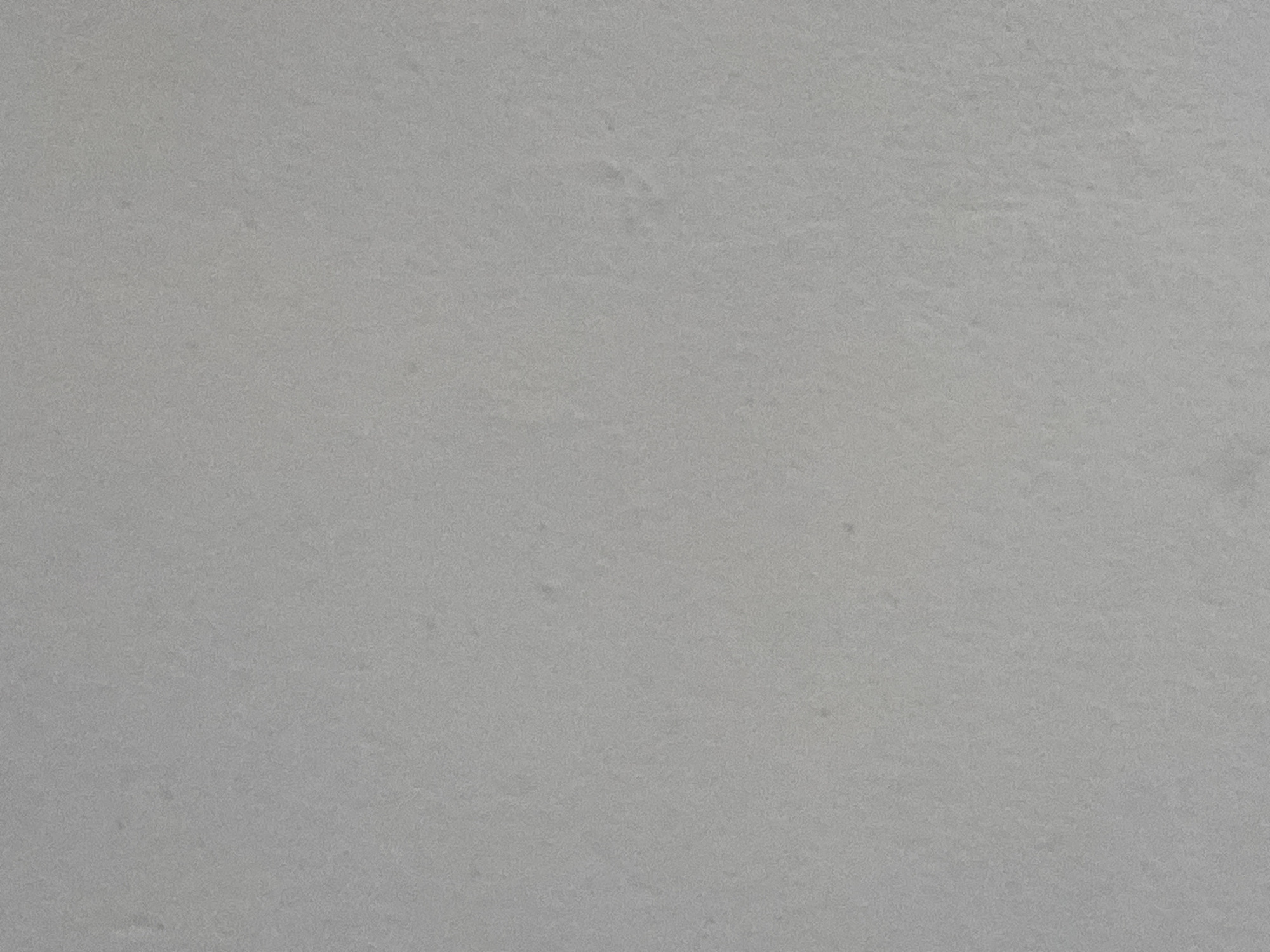 The image is a close-up, full-frame, evenly lit, and slightly textured gray surface. There are no discernable features, objects, people, or environmental details visible in the image. The image appears to be a plain, monochromatic background, possibly a wall or a piece of material. There is no information that can be extracted about the location in Jauro Yinu, Nigeria, as the image is devoid of any context.