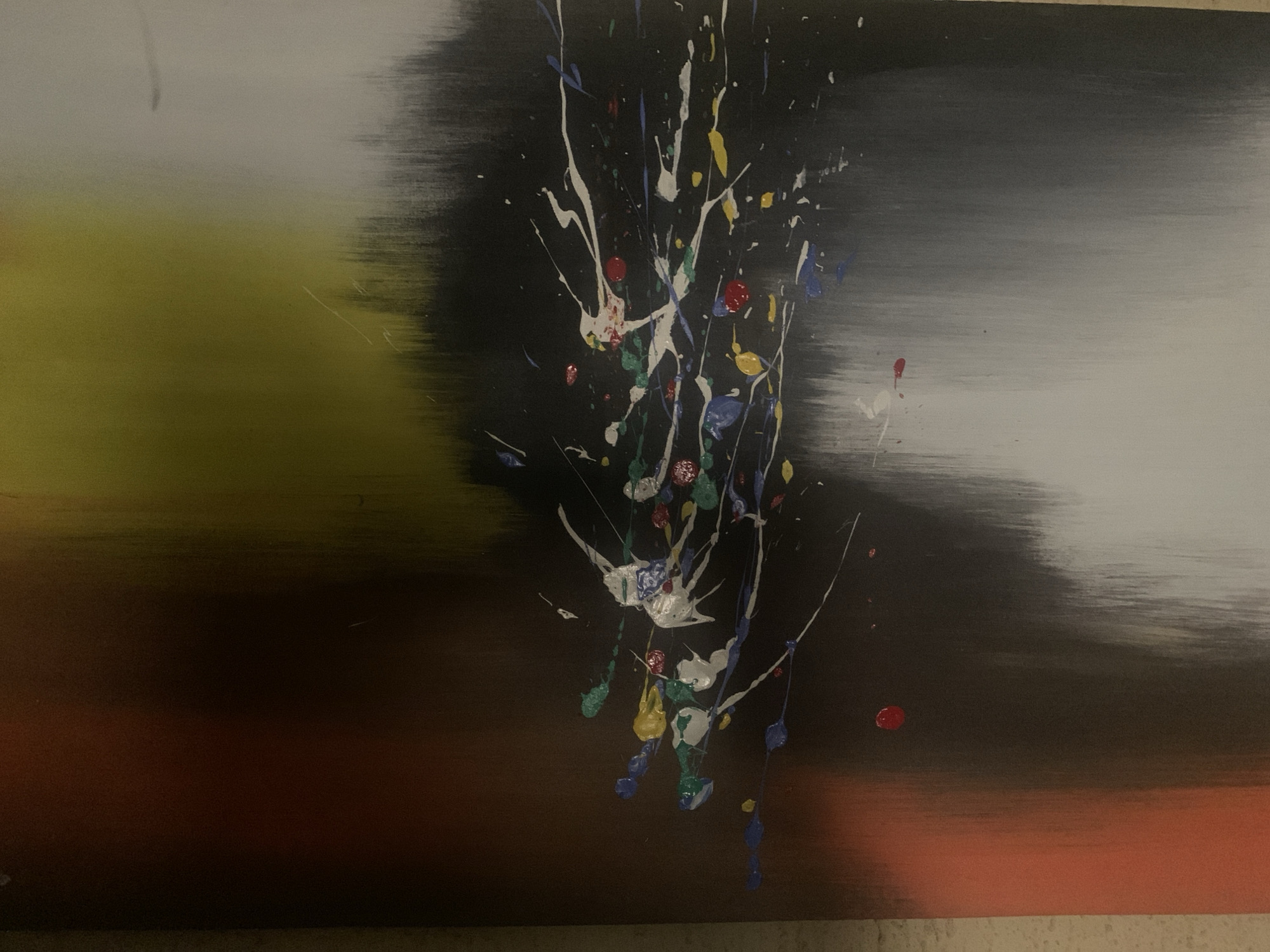 This is an abstract painting. The artwork features a blend of colors and textures, with a focus on dynamic splatters and streaks. The background transitions from a pale, almost white hue on the right, through a dark gray and black in the center, to a muted olive green and then a deep reddish-brown on the left. Splattered across the dark central area are vibrant splotches and drips of white, blue, red, yellow, and green paint, creating a sense of movement and energy. The overall impression is one of abstract expressionism, with no discernible objects or figures. The location in Jos, Nigeria, is not depicted in the image itself.