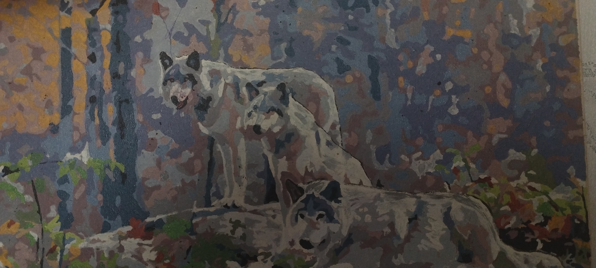 The image is a painting of three wolves in a forest setting. The wolves are depicted in various shades of gray, white, and black. The background consists of trees with blue and yellow foliage, suggesting an autumn scene. One wolf is in the foreground, facing the viewer. Behind it, two other wolves are visible, with one standing and looking to the left, and the other partially obscured by the standing wolf. The painting style appears to be that of a paint-by-numbers artwork, characterized by distinct brushstrokes and outlined areas of color. The location of Покосное, Russia is not depicted or suggested by the image.