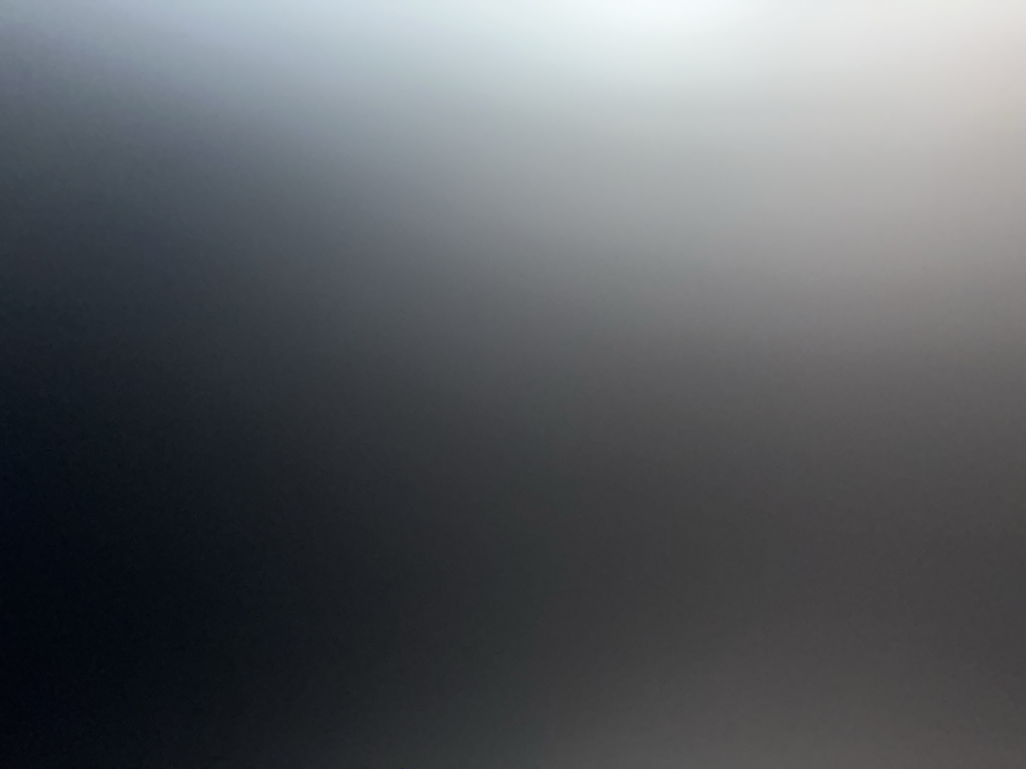 The image is a blurred, abstract photograph of a gradient of colors, transitioning from dark gray on the left to bright white on the right. There are no discernible objects, people, or environmental features visible. The location in the city of Belgrade, Serbia, cannot be determined from this image.