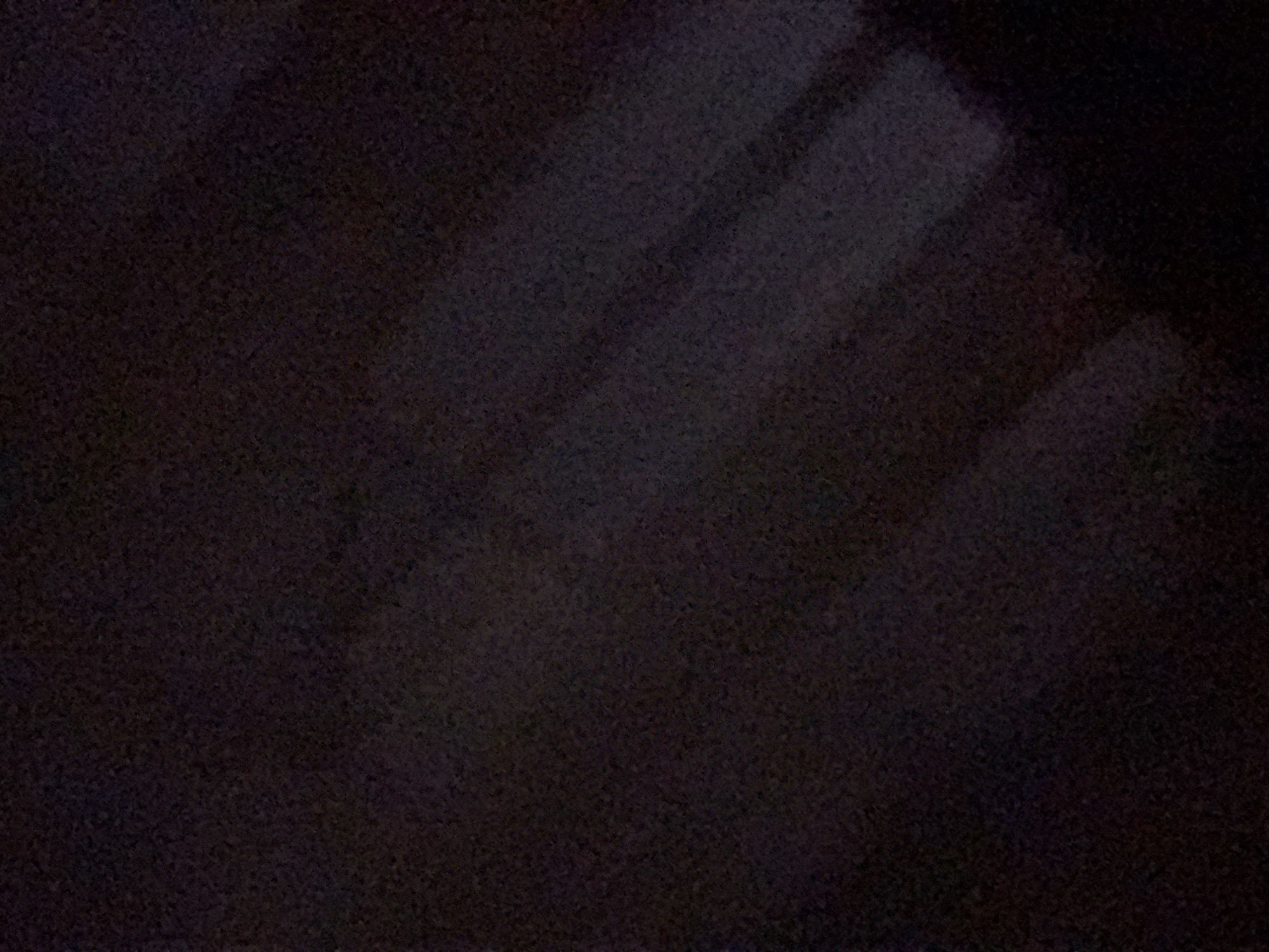 The image shows a dark, grainy surface with subtle variations in tone. There is a faint suggestion of angular shapes in the upper-right quadrant. It is impossible to determine the location in Yerevan, Armenia, or any other details about the scene due to the low image quality and lack of discernible content.