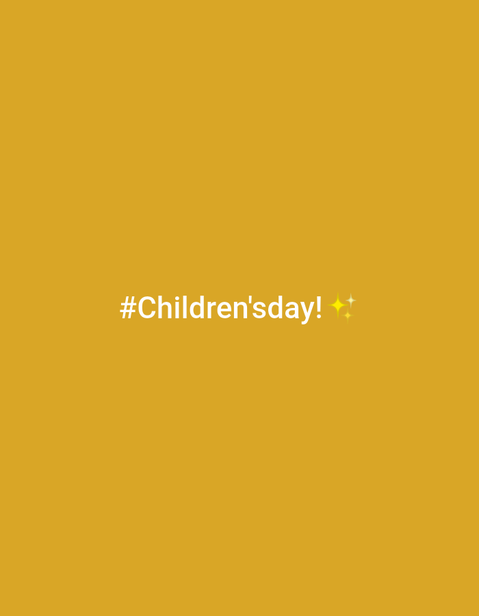The image is a solid golden yellow background with the text "#Children'sday!" in white at the center-bottom of the image. To the right of the text are two small yellow sparkles. The location of the image in Sabon Tasha, Nigeria is not visually discernible.