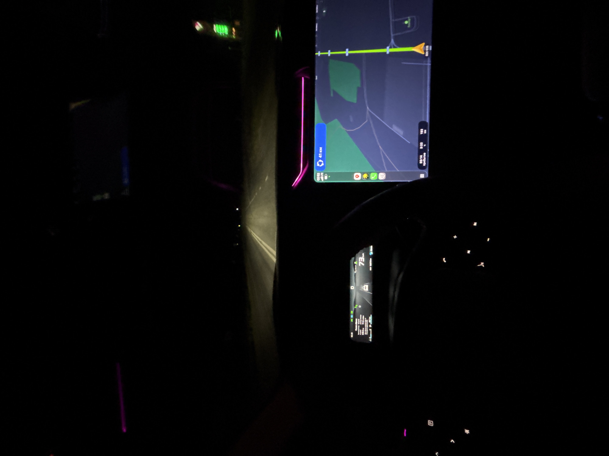 The image shows the interior of a car driving on a road at night. The car's navigation screen is visible, displaying a map indicating a distance of 41 km. The driver's dashboard displays a speed of 73 km/h. The location is not indicated but it may not be in the city of Новая Бура, Russia because the distance to destination is displayed in kilometers, not miles. The road is dark, with headlights illuminating the immediate path ahead. The interior of the car is mostly dark.