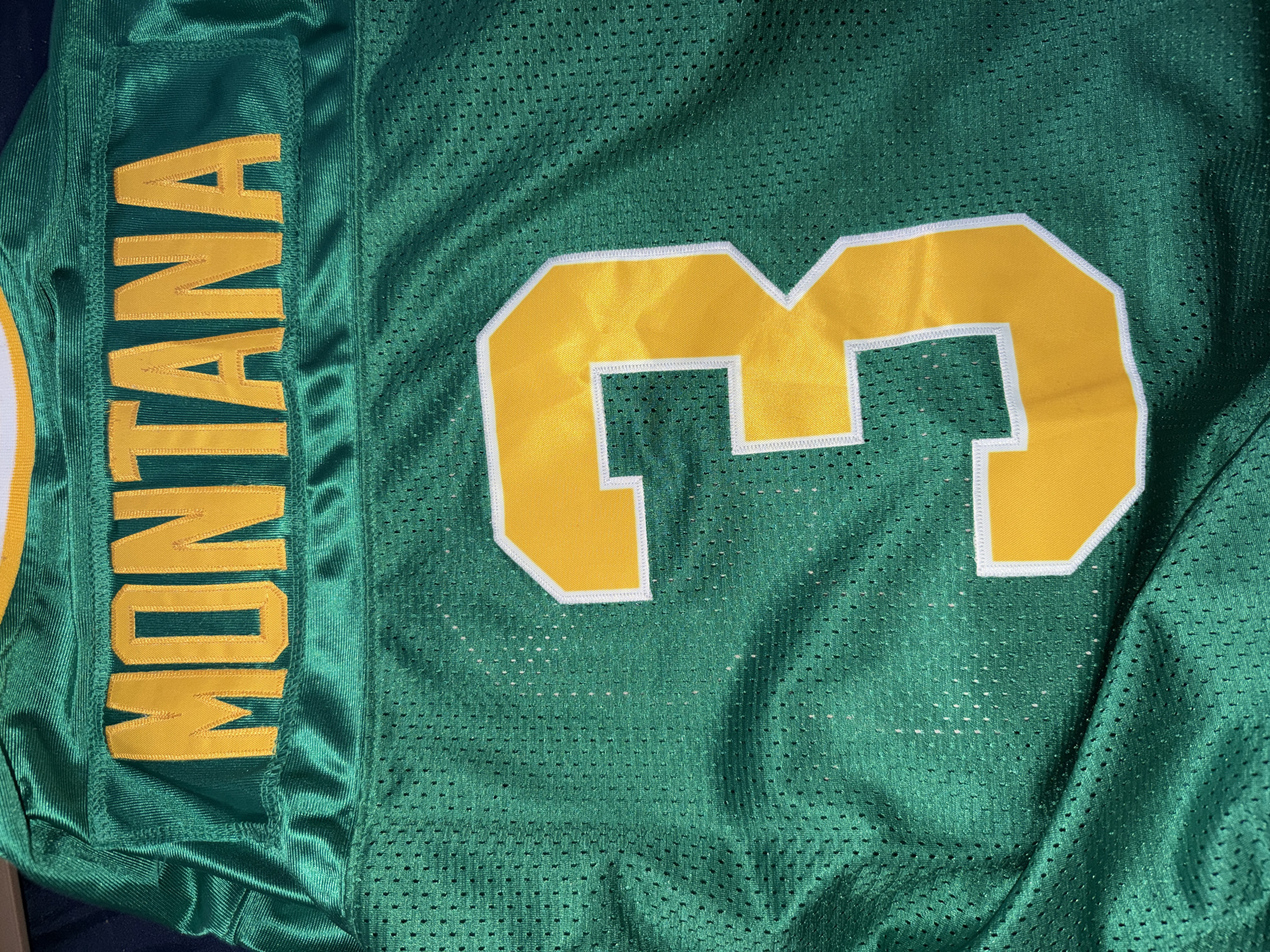 The image displays the back of a green jersey with yellow lettering. The word "MONTANA" is prominently displayed across the upper back. Below the name, a large yellow number "3" with a white outline is centered on the jersey. The fabric of the jersey is a mesh material. There is no indication of the city of Nikopol, Bulgaria in this image.