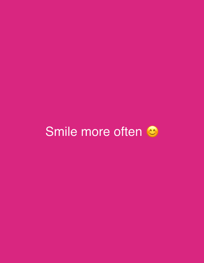 The image displays a vibrant, solid fuchsia (or bright pink) background. Centered horizontally and slightly below the vertical middle of the frame, white text reads "Smile more often". To the right of the text, a yellow smiling face emoji with smiling eyes (😊) is present, completing the message. There are no other discernible subjects, objects, or activities depicted. The overall impression is one of a simple, positive, and encouraging message.