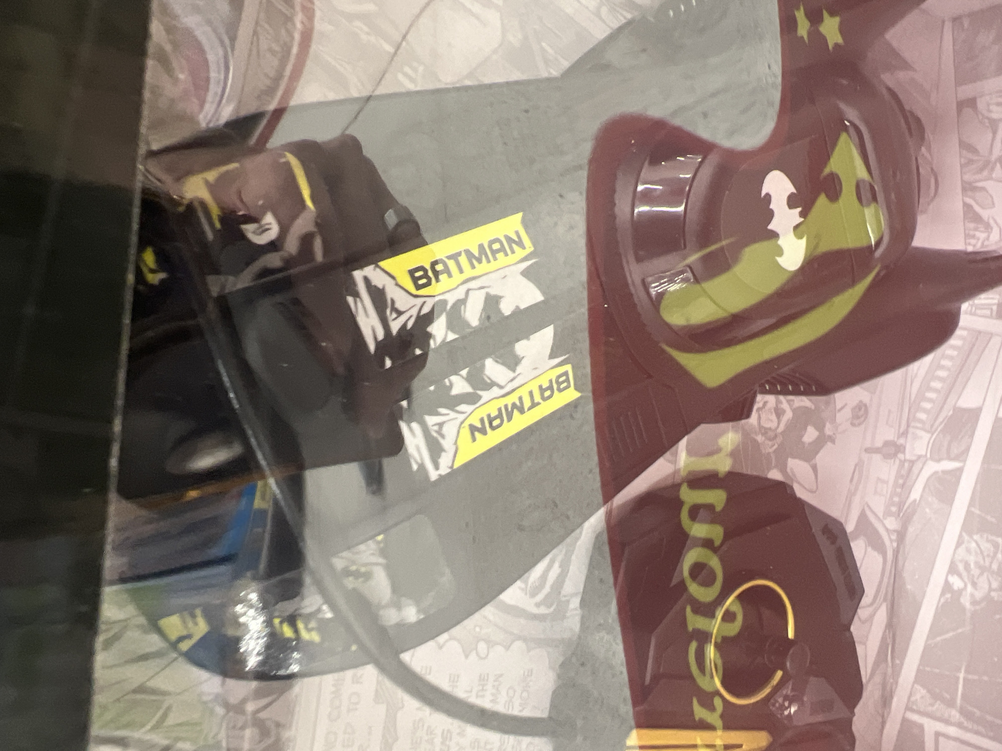 The image shows a Batman-themed toy car in its packaging. The packaging includes text and images related to the Batman character. The toy car is prominently labeled with the word "BATMAN" on its packaging, while another part of the package includes "USICION". The background features comic book-style artwork. The location in Buenos Aires, Argentina is not apparent from the provided image.
