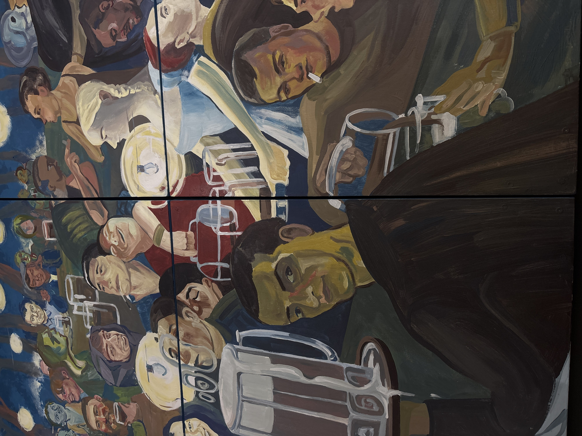 The image depicts a mural painting showing a scene with people, beer steins, and tables. The mural is composed of four panels. The subjects are individuals, seemingly in a bar or pub, drinking and interacting. Some are holding or near beer steins. One man is holding a cigarette. The environment appears to be a crowded gathering place, possibly the interior of a bar. It is found in the city of Perm, Russia.