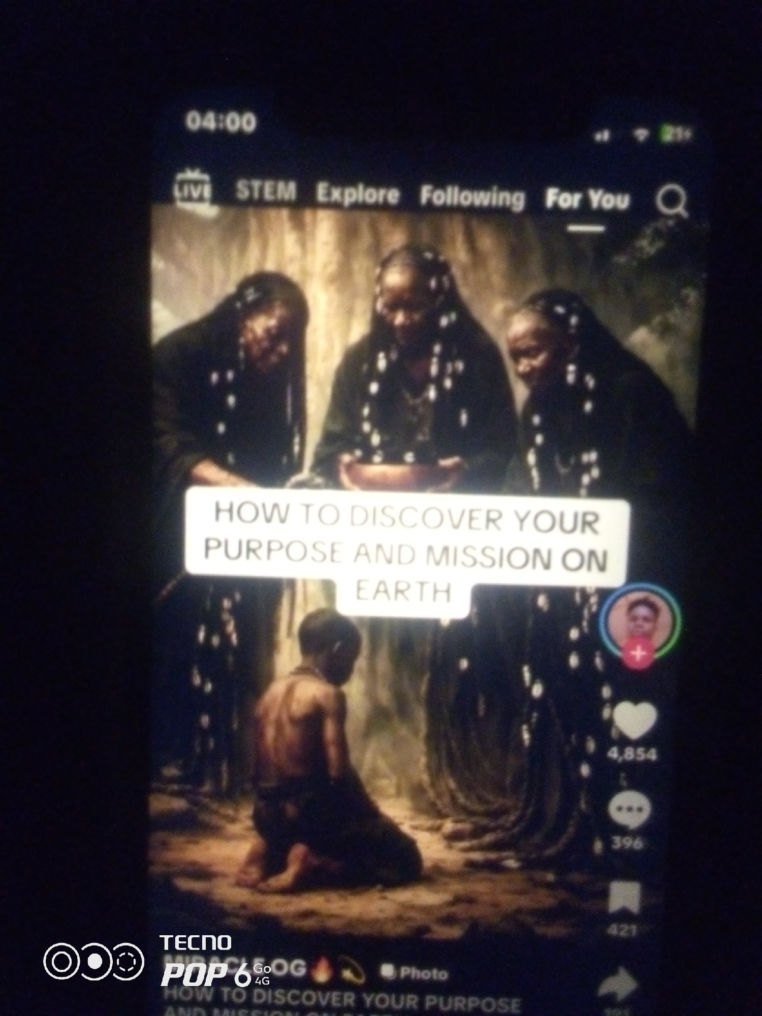 The image displays a screenshot of a mobile phone screen, likely from a social media platform like TikTok or Instagram. The content shows a video with three women in dark attire with beaded adornments, appearing to be in a spiritual or ceremonial setting. In the foreground, a young boy is kneeling. A text overlay on the video reads "HOW TO DISCOVER YOUR PURPOSE AND MISSION ON EARTH". On the right side of the screen, there are social media interaction icons including a profile picture with a plus sign, a heart icon with a count of 4,854, a speech bubble icon with a count of 396, a bookmark icon with a count of 421, and a share icon. At the bottom left, there is a logo that reads "TECNO POP 6 4G". The overall lighting is dark, suggesting the video or the environment it depicts is dimly lit. There is no discernible information within the image to indicate the location as Howayi, Nigeria.