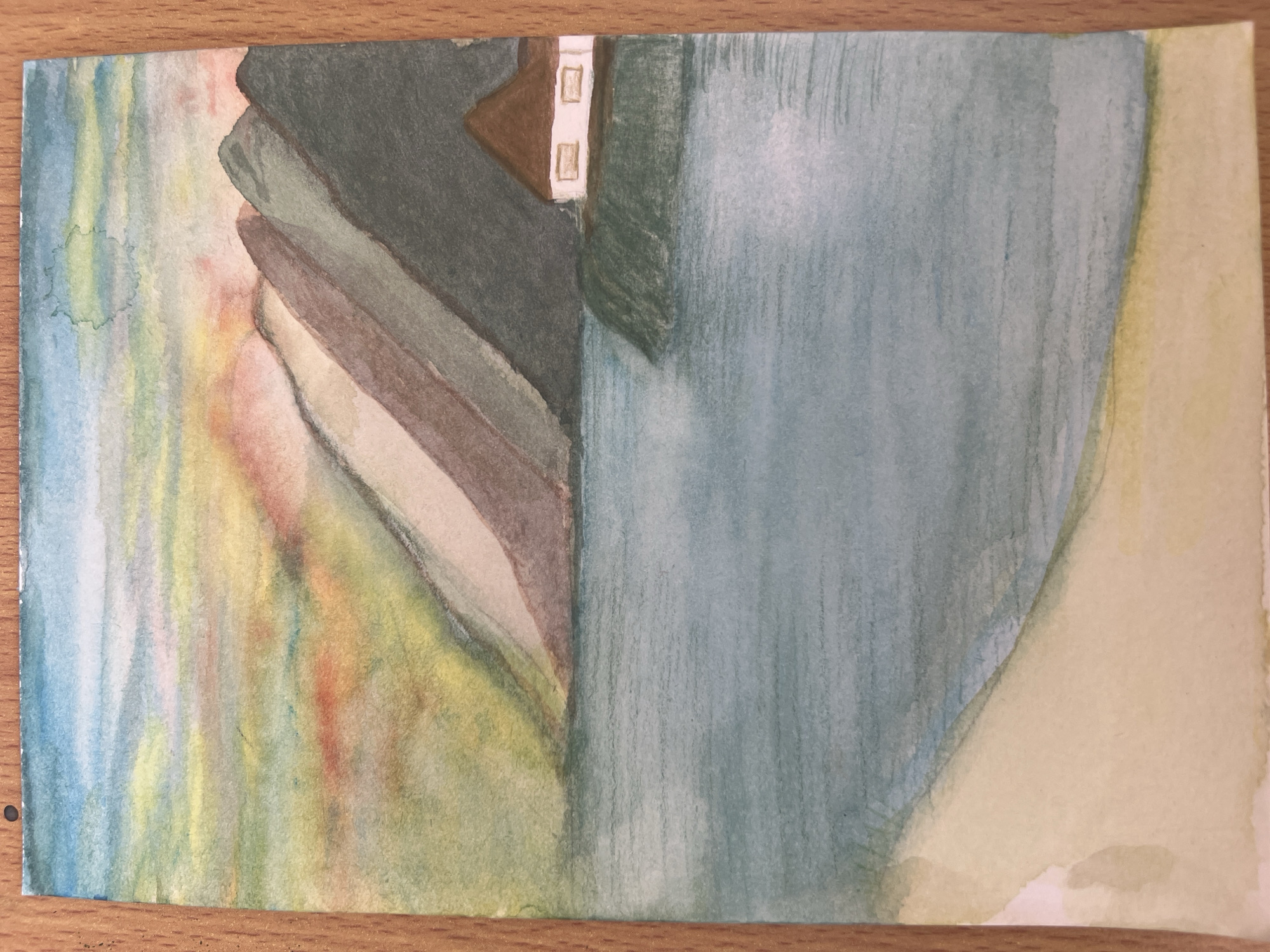 The image is a watercolor painting depicting an abstract scene. On the left, a vertically-oriented band of blended colors from blue to yellow and red creates a blurred, undefined space. Adjacent to this, stacked layers of gray, brown, and cream tones suggest a structure or landform. A small triangular brown shape with two white rectangles positioned vertically above each other emerges from the gray, possibly suggesting a building detail.
On the right, a large area of light blue washes dominates the view, with vertical brushstrokes. This shape flows into a pale yellow area to its right.
There are no people, discernible subjects, explicit objects, actions, or interactions depicted in the painting. The location of Baošići, Montenegro is not evident from the painting itself.