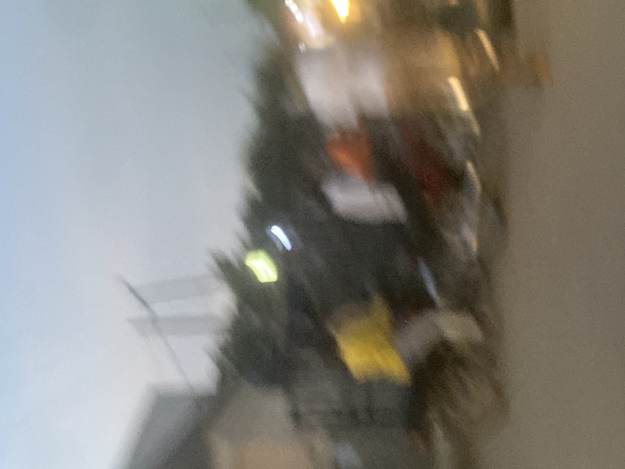 I cannot reliably determine the location in Abuja, Nigeria, due to the blurry and ambiguous nature of the image. Based on the image, I can observe the following:
- There appear to be multiple people or objects present, but their exact number and features are indistinct due to the blur.
- The scene seems to be outdoors, potentially in a city setting, given the presence of structures and possible street lighting.
- Some colors, like yellow, red, and green, are vaguely discernible.
Without further information or a clearer image, I cannot provide a more detailed forensic description.