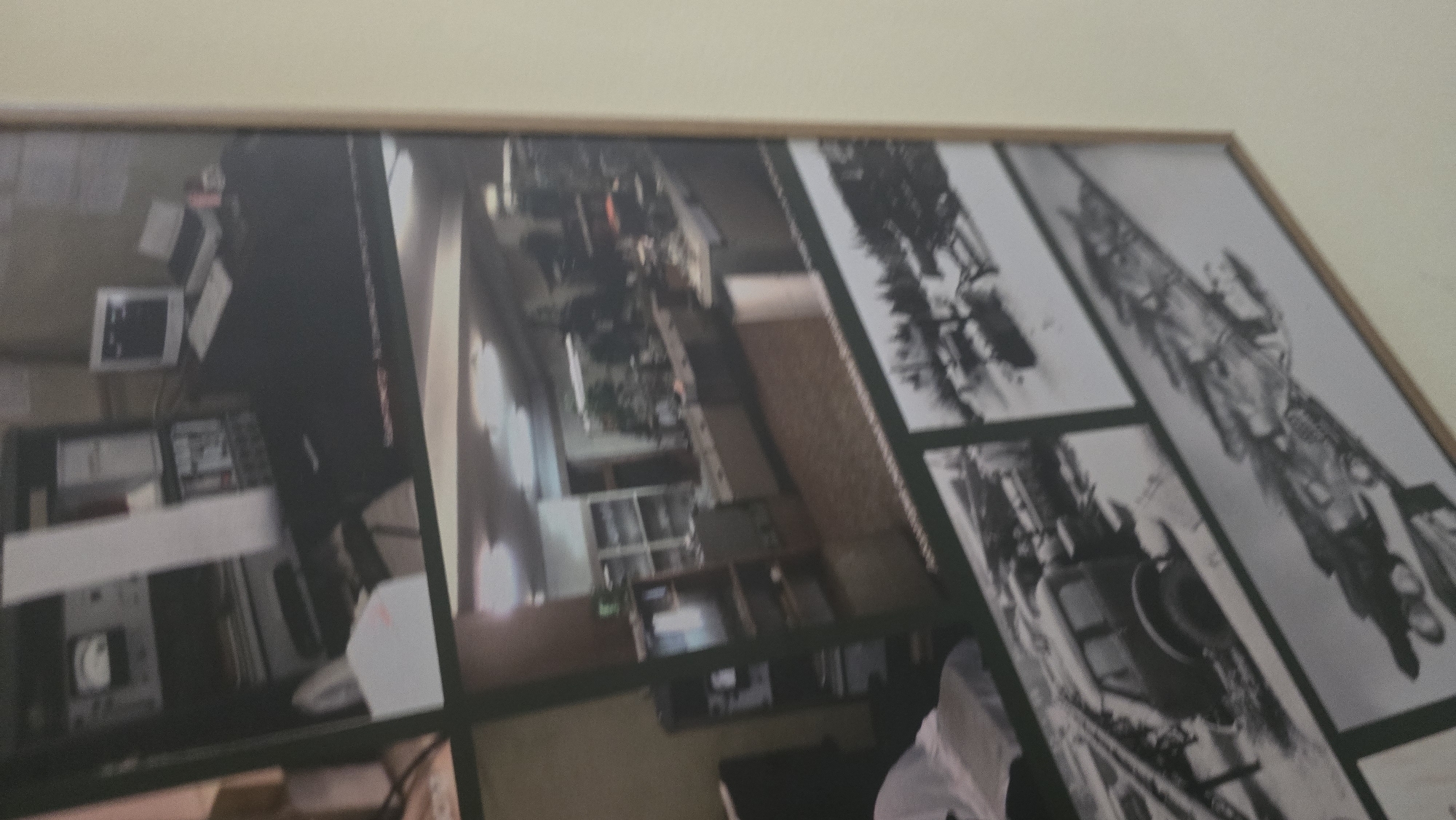 The image is a collage of several photographs framed and hanging on a light-colored wall. The photographs depict different scenes, including an indoor laboratory or workshop setting with electronic equipment, shelves filled with items, and a desk with a computer. Another photograph shows a store or showroom with display counters and shelves. The lower portion of the collage features black and white photographs of what appear to be vehicles, possibly military or industrial, in snowy environments, and a blurred image of what could be an aircraft or a large machine. The overall presentation suggests a historical or documentary compilation of images. The context of Ukhta, Russia, is not visually evident within the photographs themselves, nor is there any text visible to identify the location.