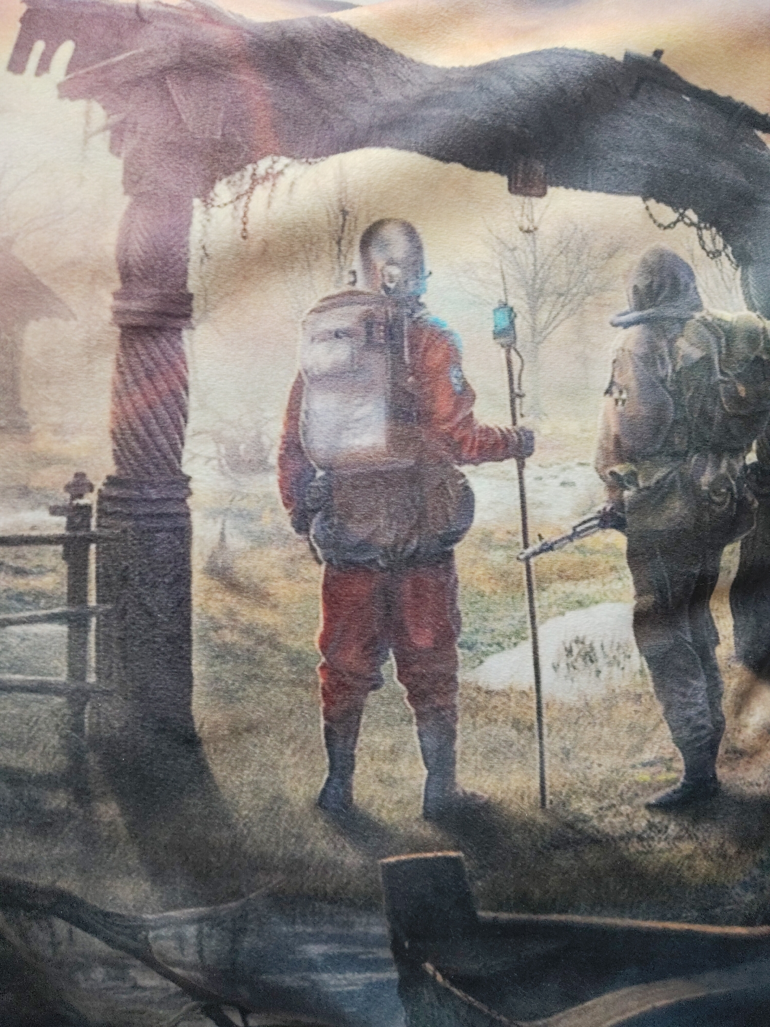 Two figures wearing protective gear are walking in a foggy, desolate landscape. The figure on the left wears a red suit and backpack, carrying a rod with a device attached. The figure on the right wears a dark grey suit and backpack, carrying a rifle. They are walking under an archway with deteriorated columns. The background shows sparse vegetation and distant buildings. The setting appears to be a post-apocalyptic or contaminated zone.