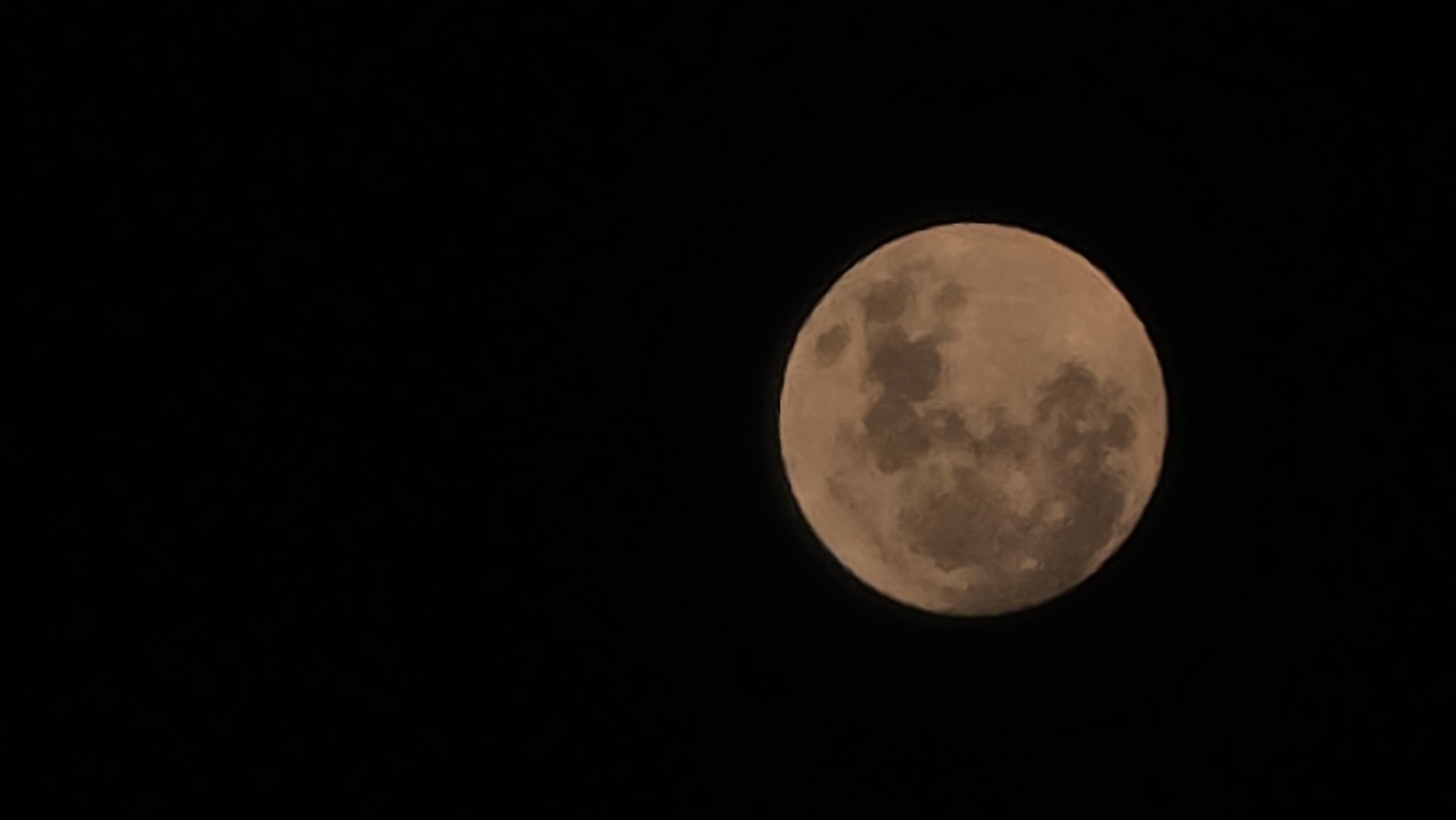 The image shows a full moon against a black sky. The moon is slightly orange in color and displays surface details such as craters and maria. There is no indication of the location of Rogachevo, Bulgaria, in the image. No people or interactions are visible.