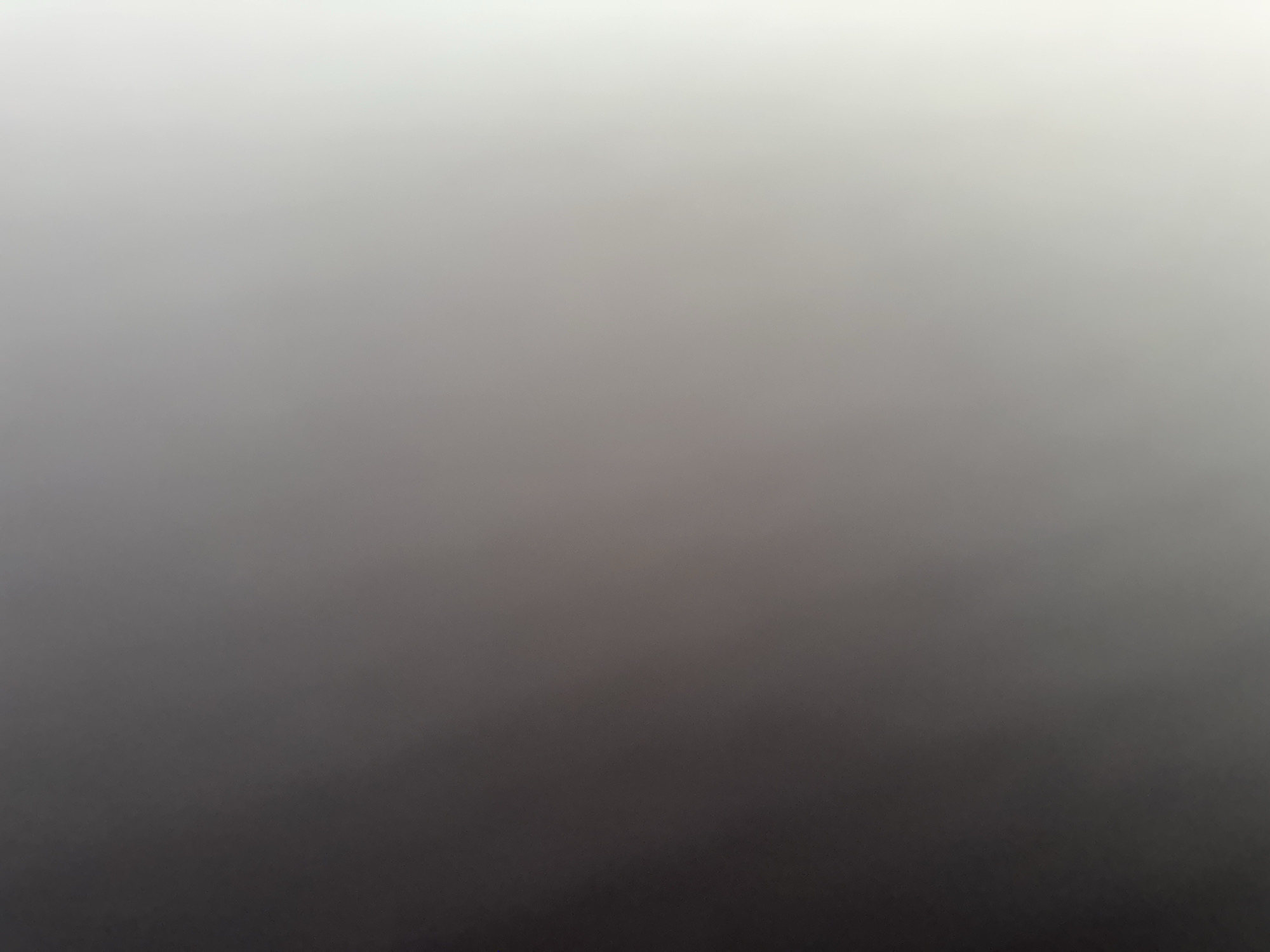 This is a photograph with a smooth gradient from white at the top to black at the bottom, suggesting a very soft, diffused light source. There are no discernible subjects, objects, scene, or setting visible. No activity or event is taking place. There are no notable details such as time of day, weather, location cues, or emotions. There is no visible text. The image appears to be an abstract gradient of light and shadow.