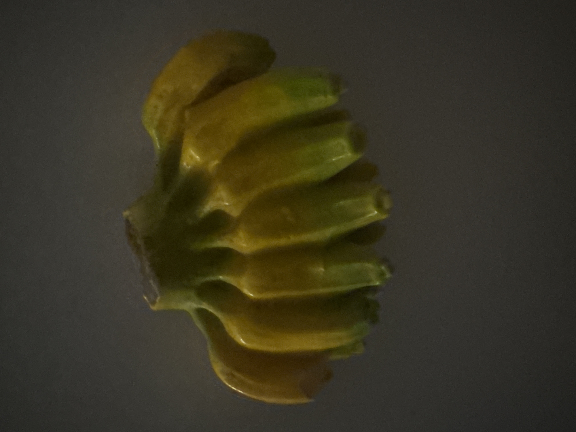 The image shows a cluster of small, yellow-green bananas. There is no indication of the location being Krasnoyarsk, Russia, or any other specific location. The bananas appear to be resting on a dark, indistinct surface.