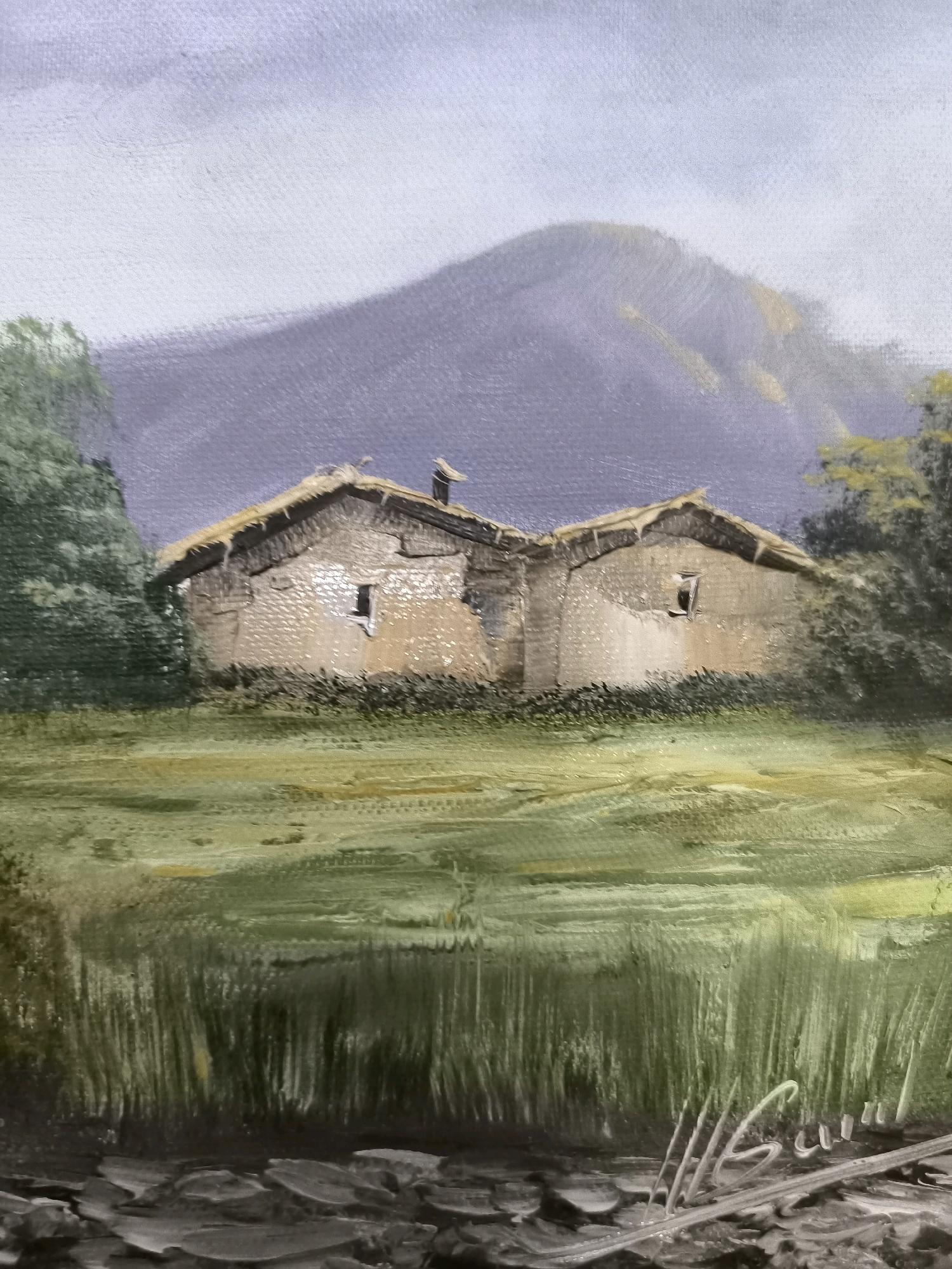 The image is a painting of a rustic dwelling with a thatched roof, situated in a landscape with a large hill in the background. The dwelling appears to be made of stone or mud-brick, with a prominent chimney. In the foreground, there is tall grass or reeds, and the ground is depicted with rough, textured strokes that could represent stones or earth. The sky is overcast. There are no people or animals visible in the scene, and no specific landmarks are identifiable that would place this scene within the city of València, Spain. The painting style is impressionistic, with visible brushstrokes and a muted color palette.