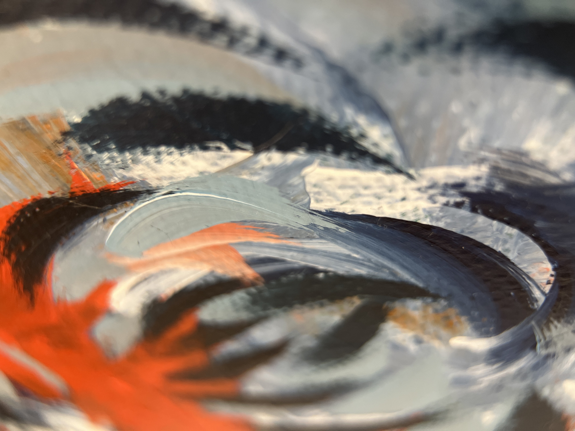 The image is a close-up of an abstract painting. The colors are primarily red, white, blue, and black. The paint appears thick and textured. There is no information in the image to identify its location in Tyumen, Russia, nor any people, subjects, objects, actions, interactions, or environment. The image focuses solely on the paint and its texture.