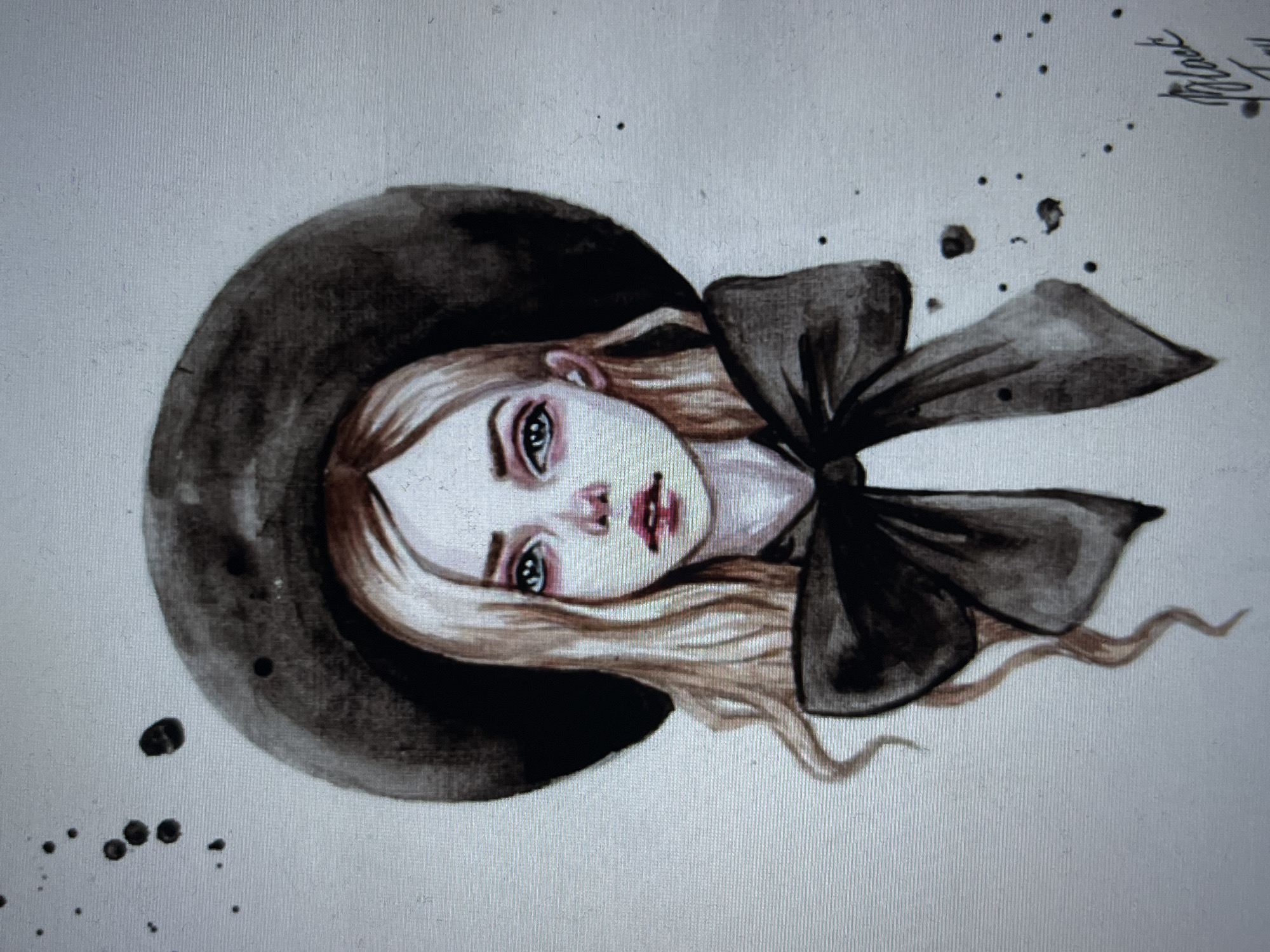 This is a watercolor painting of a young woman wearing a large, dark hat and a black bow. She has blonde hair and large, expressive blue eyes with dark circles underneath. Her lips are a deep pink. The painting has a slightly melancholic or ethereal feel, with dark splatters of paint around the subject, adding to the artistic style. There is a signature in the lower right corner which appears to read "Black Toy." The painting is on a textured white background. There is no information available regarding its location in the city of Ustyvytsia, Ukraine.