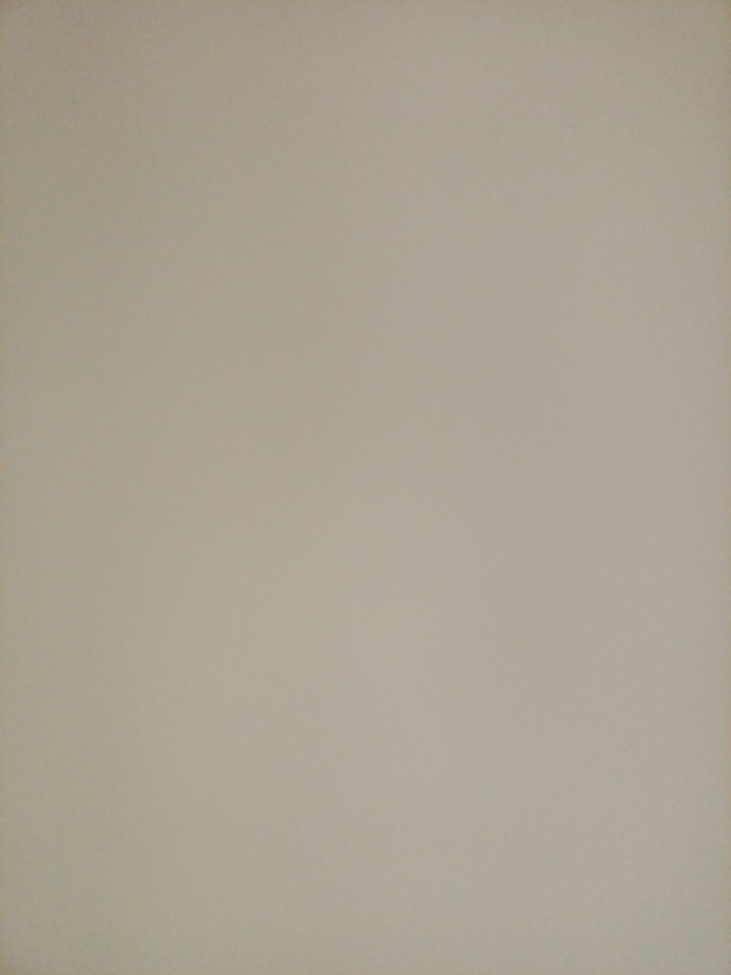 The image is a full-frame, close-up shot of a plain, light beige wall. The surface appears to be textured, with a subtle grain visible, possibly due to the material of the wall or the resolution of the image. There are no discernible objects, people, or distinguishing features present in the scene. The lighting is even and diffused, casting no shadows. The photograph is an unidentifiable location within the city of Rostov-on-Don, Russia, as there are no landmarks or contextual clues to suggest its specific whereabouts.